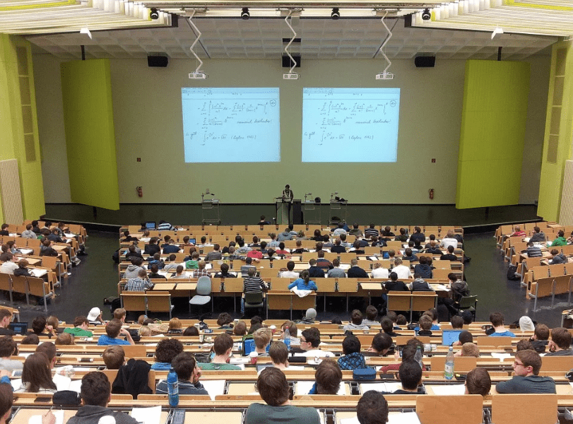 An image of university students receiving lectures in a hall. | Photo: Pixabay.