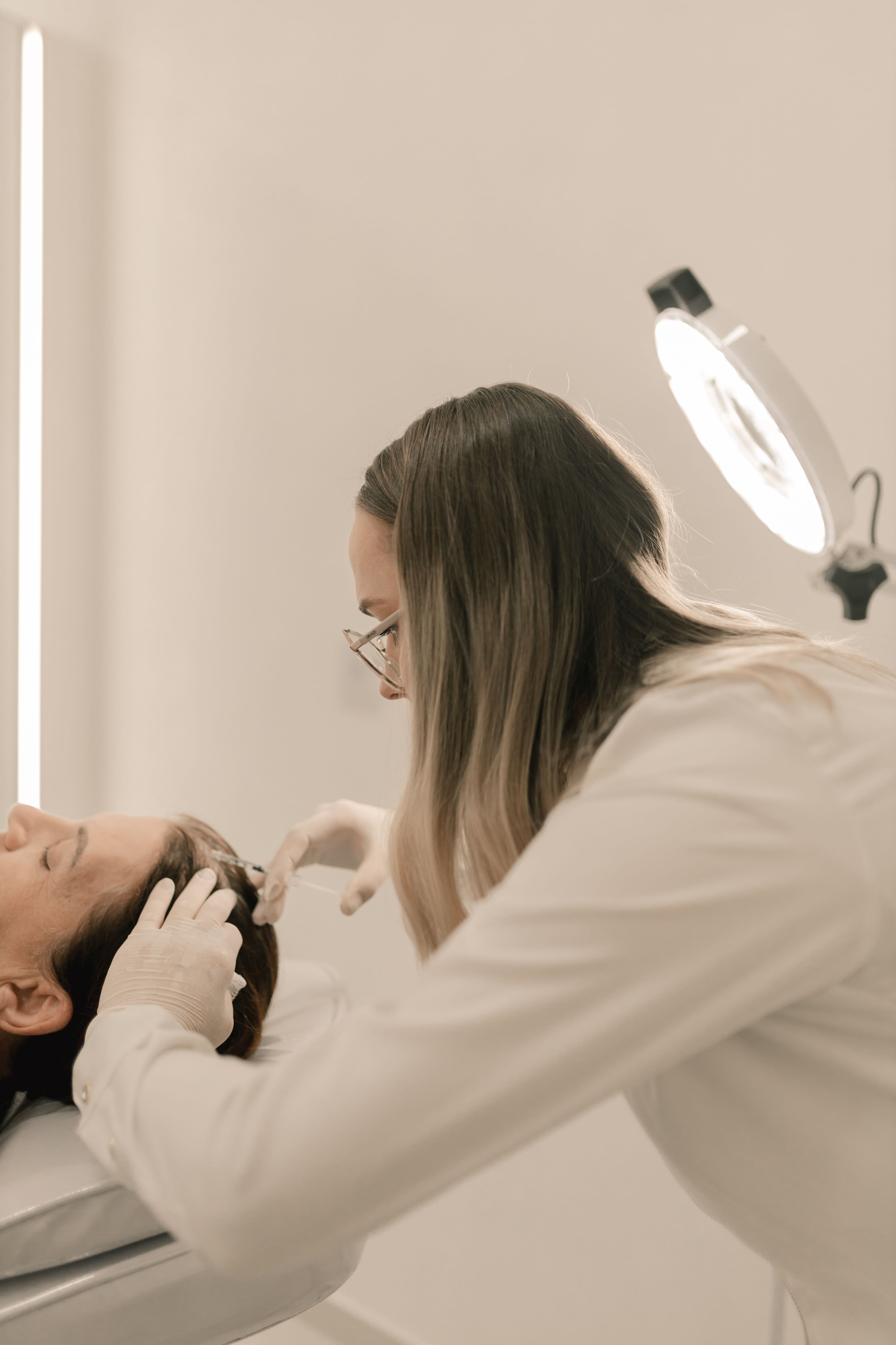 A professional inspecting a woman's scalp | Source: Pexels