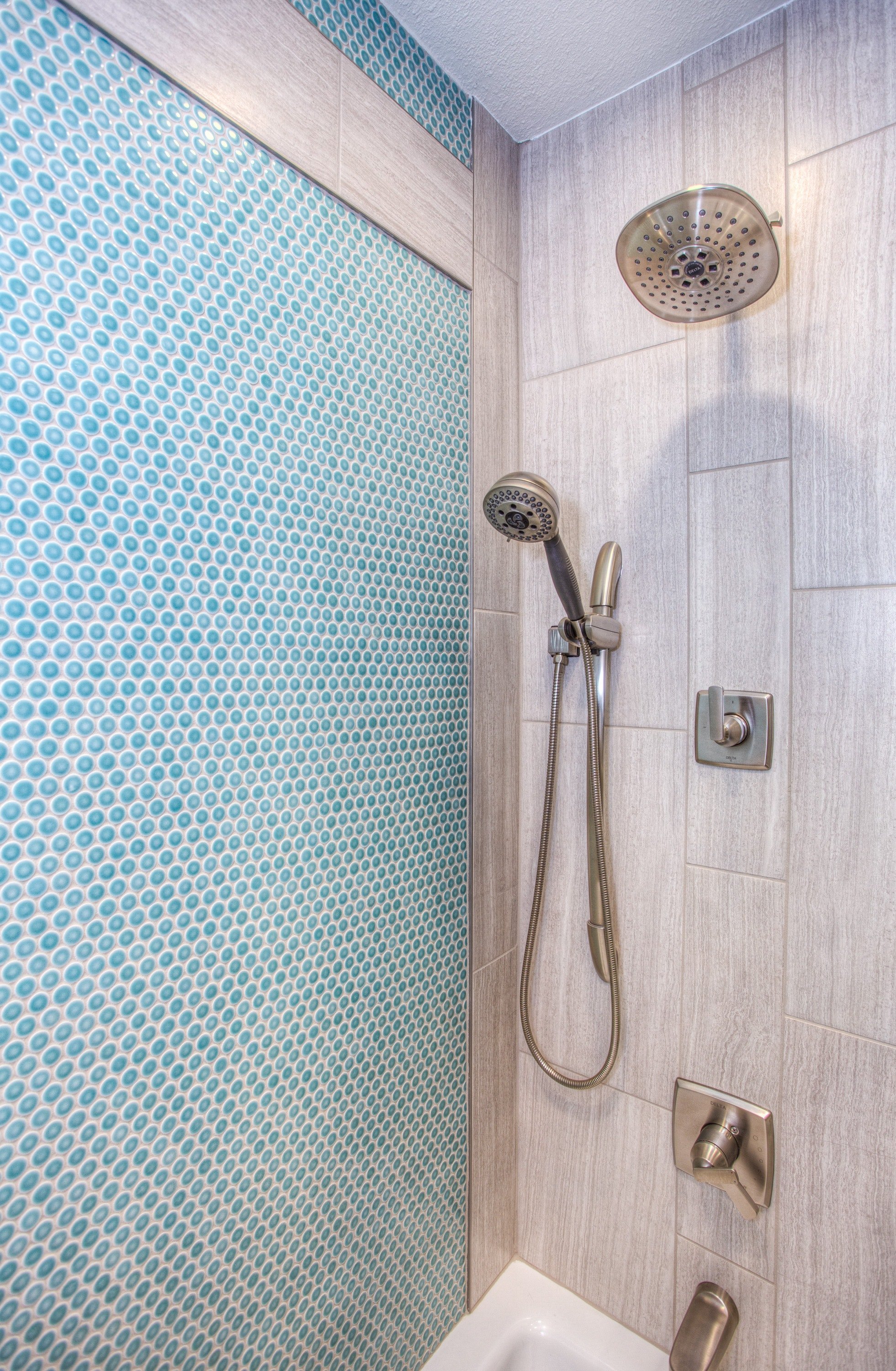 Una ducha de mano colgada en una pared dentro de un baño. | Foto: Pexels
