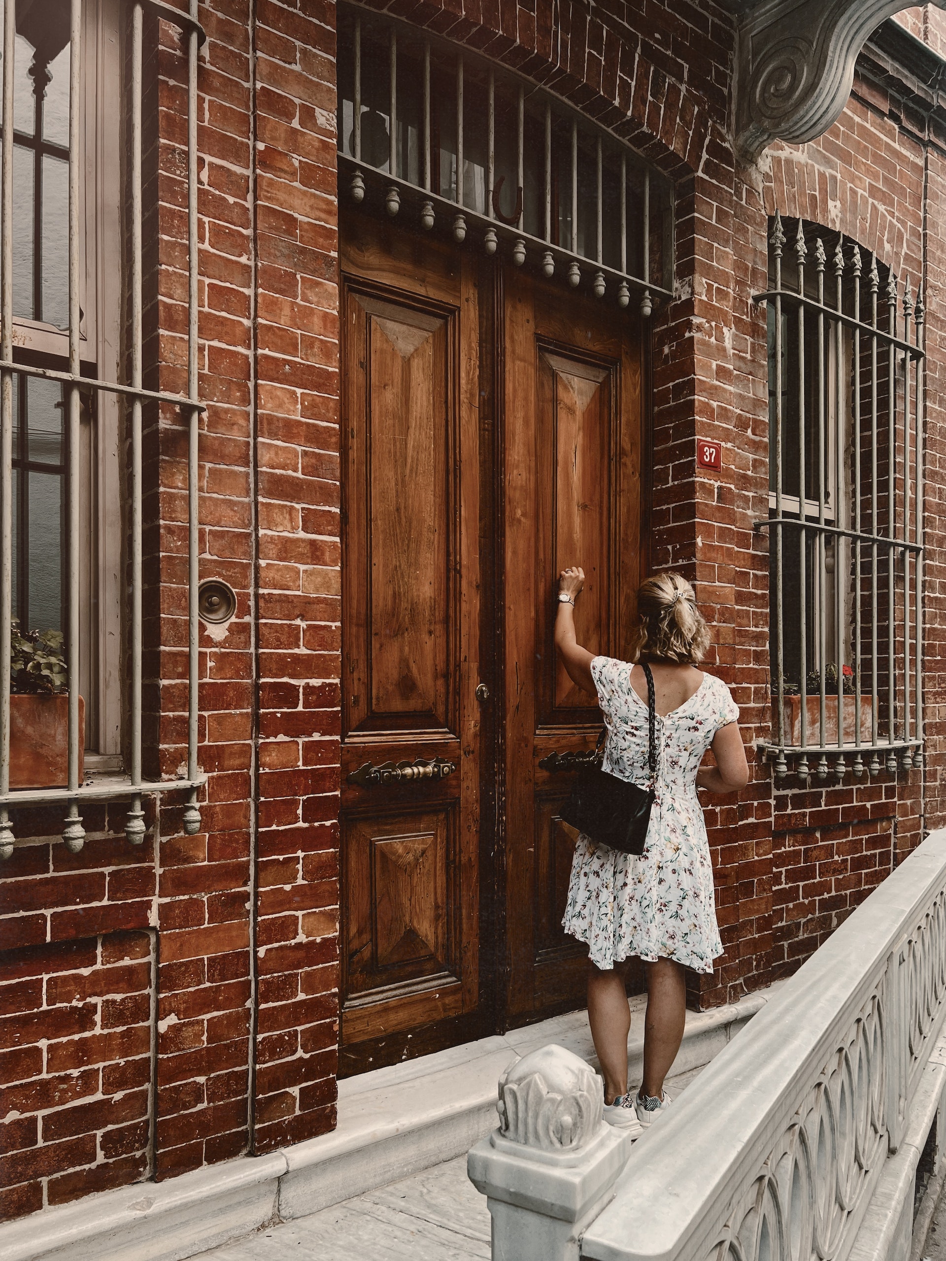 A woman knocks on a wooden door | Source: Pexels