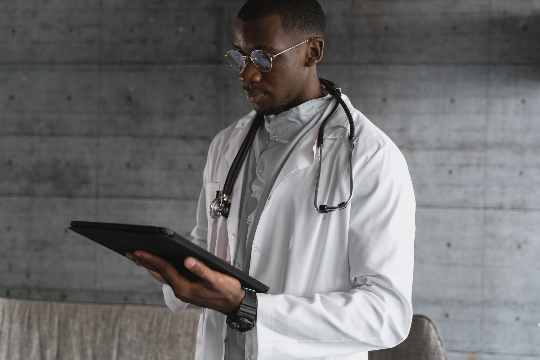 A doctor holding the black tablet. | Photo: Pexels