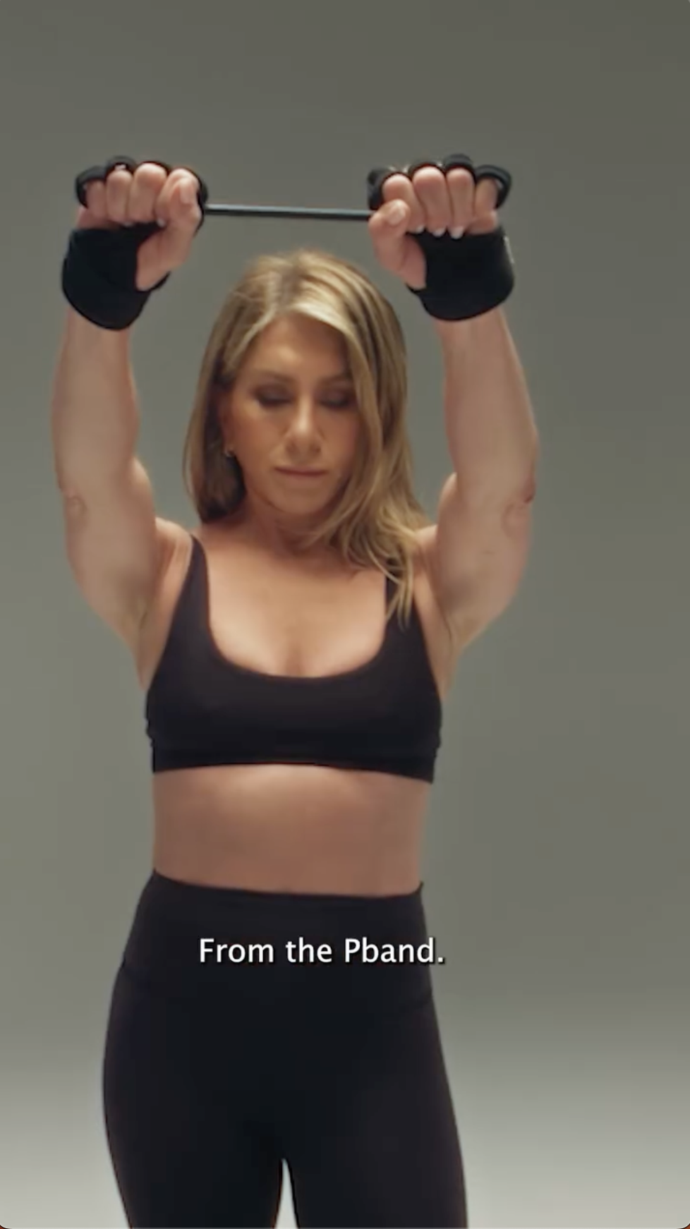 Jennifer Aniston uses the P.band, lifting her arms with resistance to engage her shoulders and upper body | Source: Instagram/pvolve