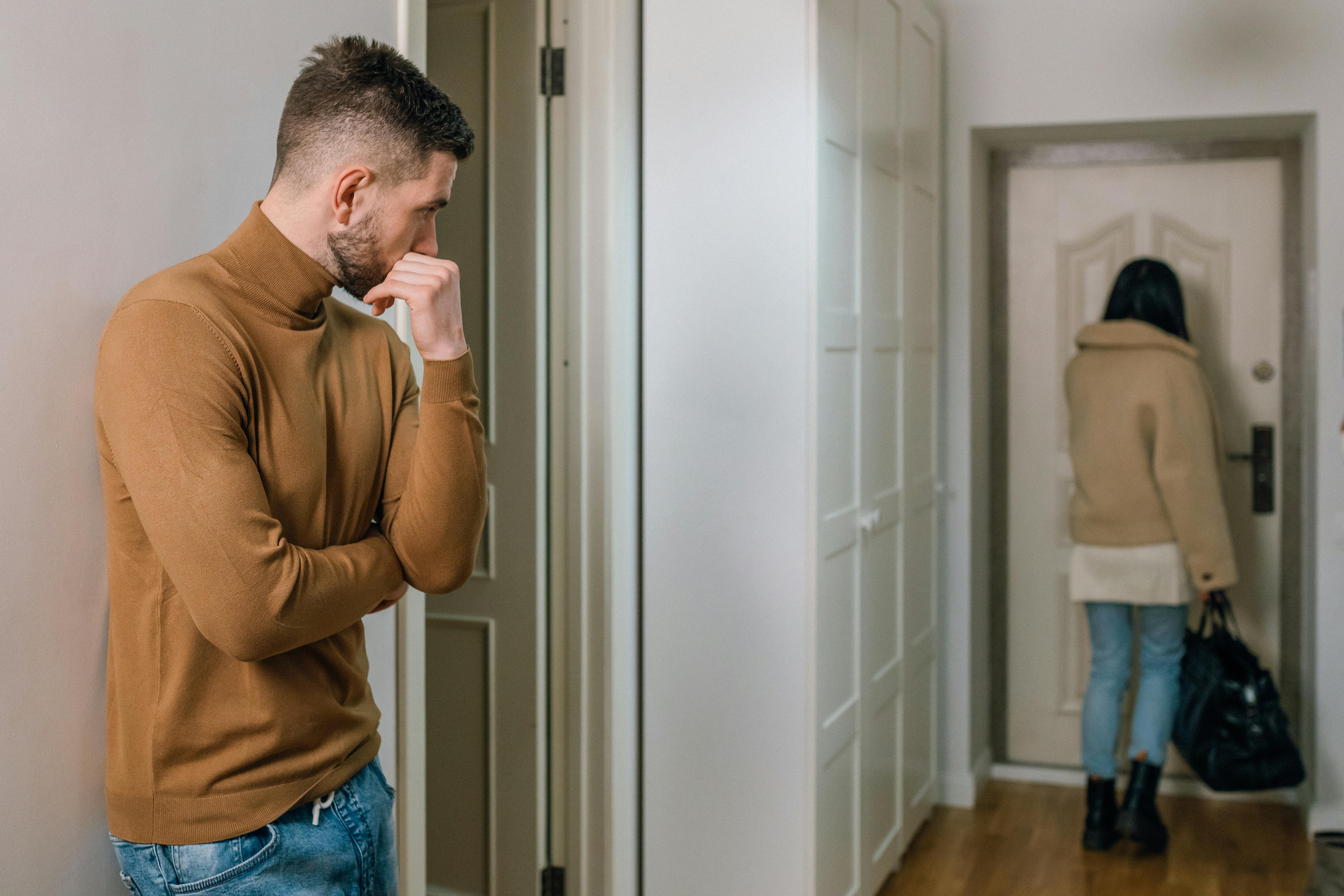 A man watching as his partner leaves their apartment with a bag | Source: Pexels