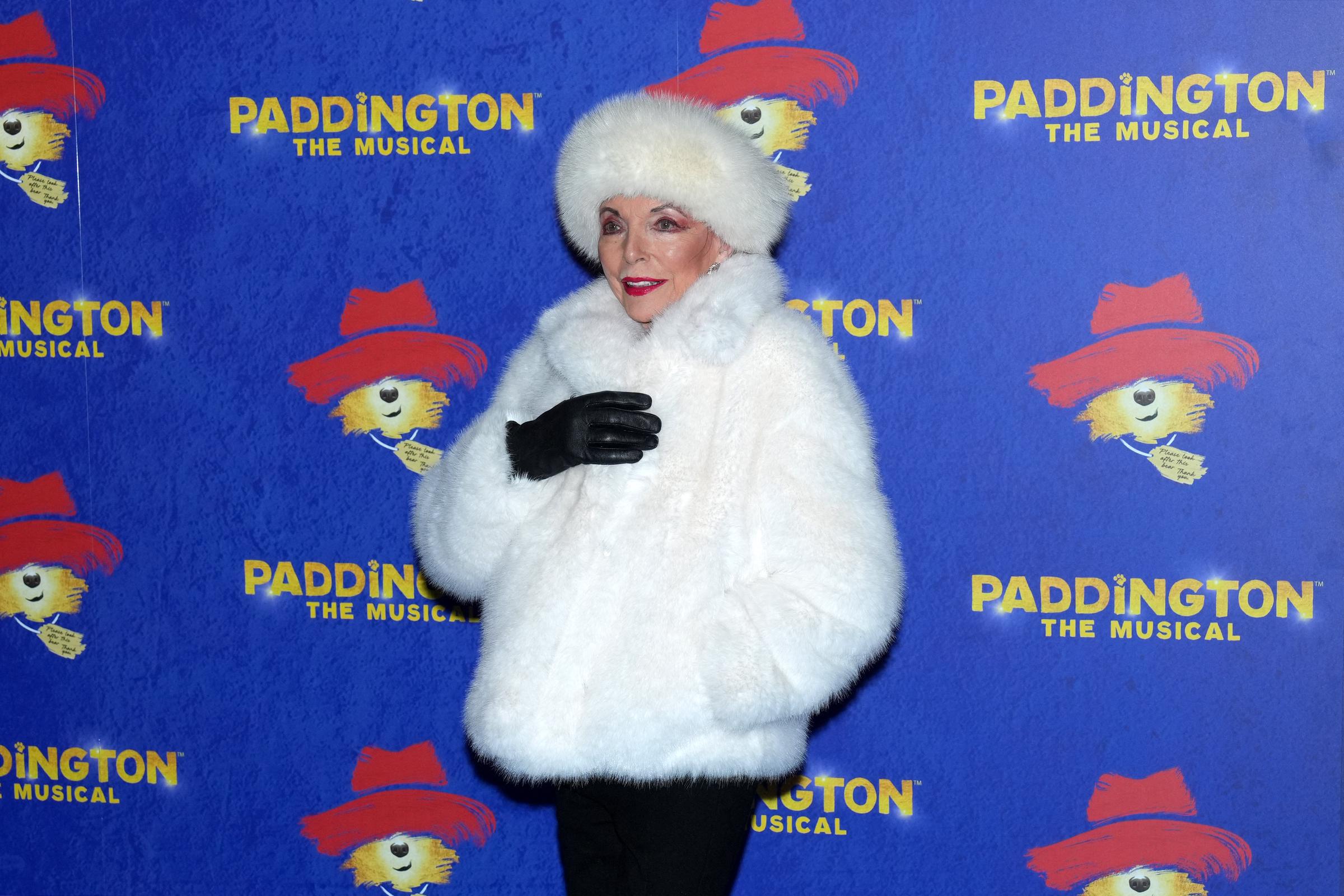 Stepping back to reveal the fuller ensemble, Collins paired her fur coat with black trousers and knee-high boots — a practical yet polished choice for the chilly London evening. Her posture and presence on the blue carpet commanded attention with characteristic ease.