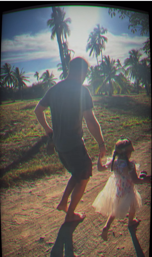 Prince Harry and Princess Lilibet walk hand in hand along a palm-lined path, silhouetted by the glow of the afternoon sun. | Source: Instagram/meghan
