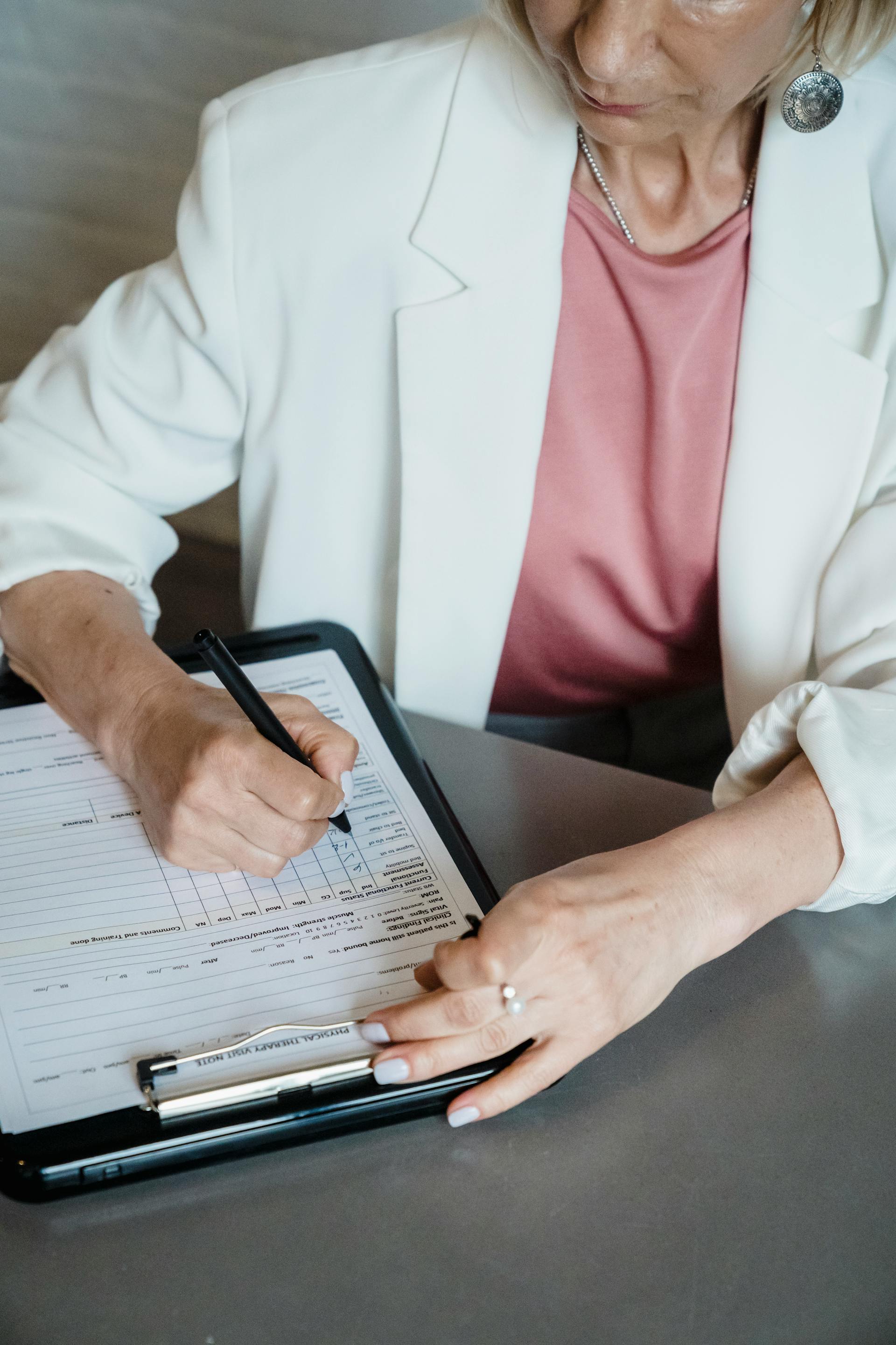 A female therapist filling a document | Source: Pexels