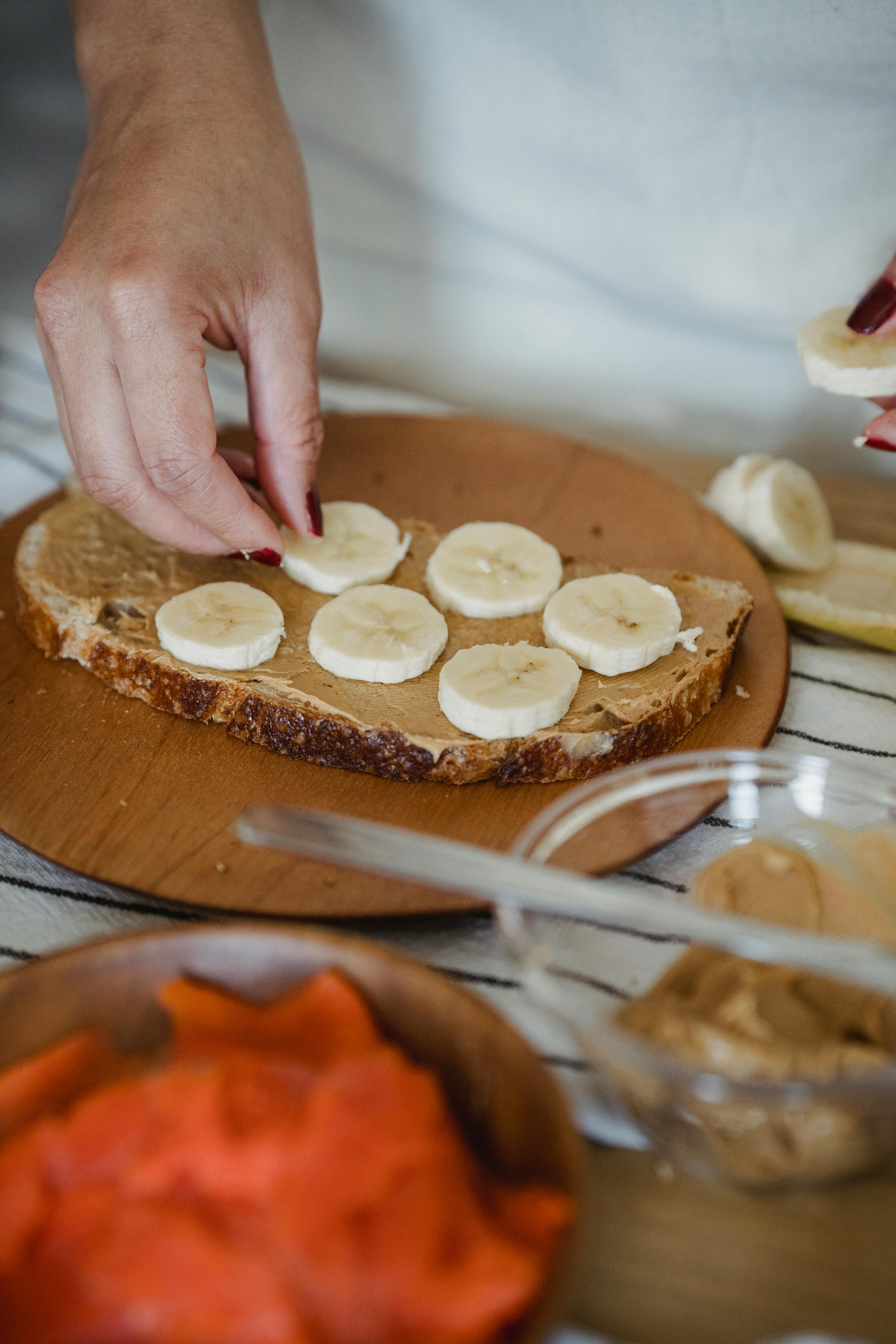 A woman making a peanut butter and banana sandwich | Source: Pexels