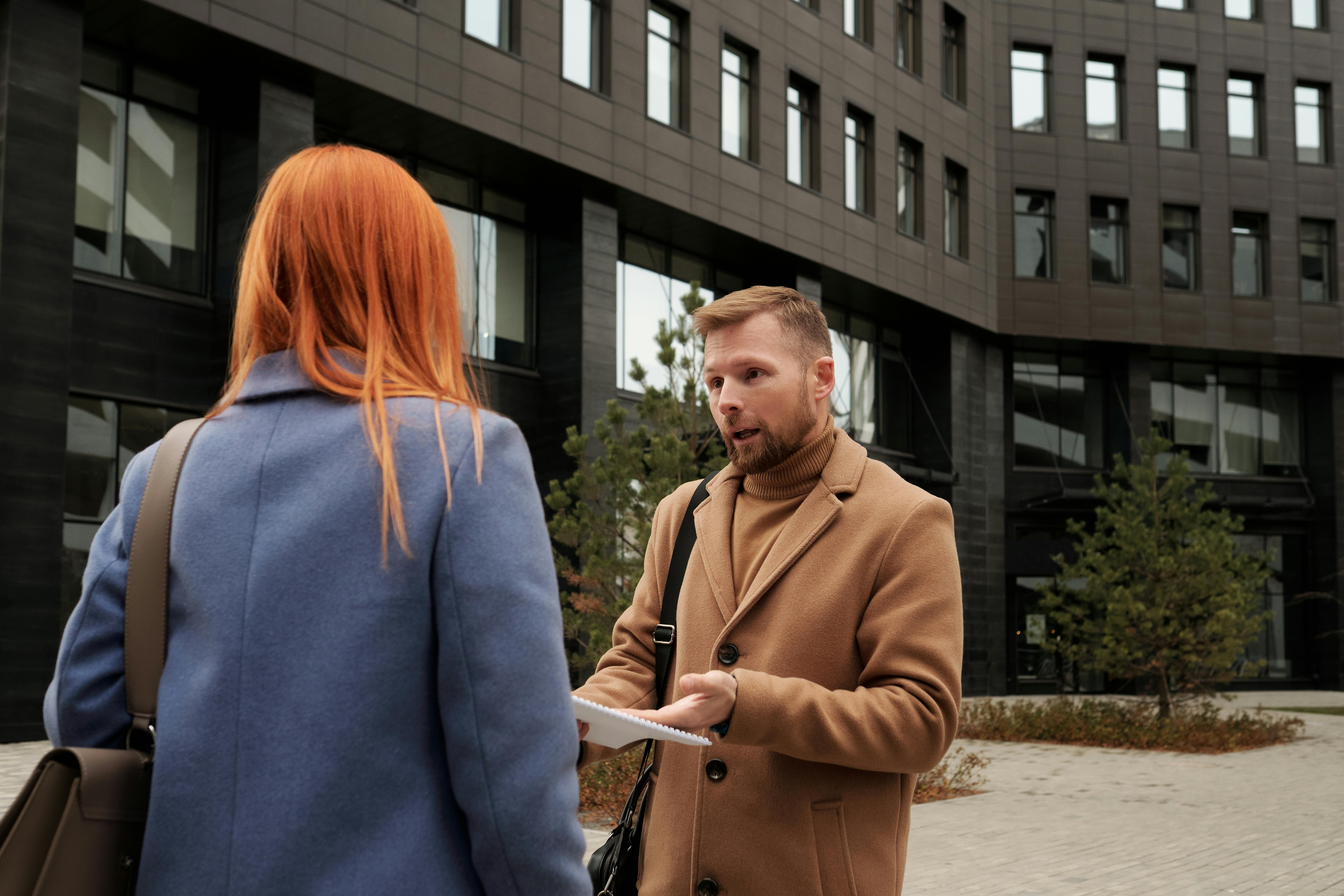 A man and a woman having a serious discussion outside a building | Source: Pexels