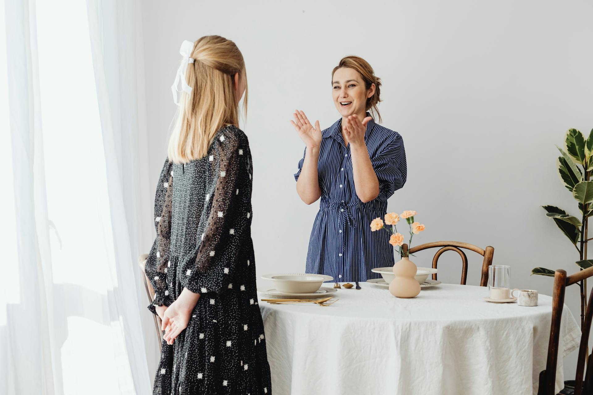 A smiling woman telling a story to her teenage daughter | Source: Pexels