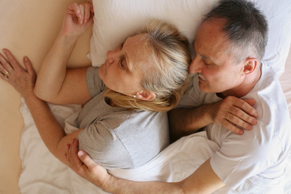 Elderly couple laying together | Shutterstock