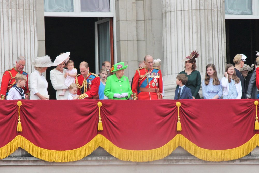 La princesa Charlotte en brazos de su madre, acompañadas de la familia real británica. | Foto: Shutterstock.