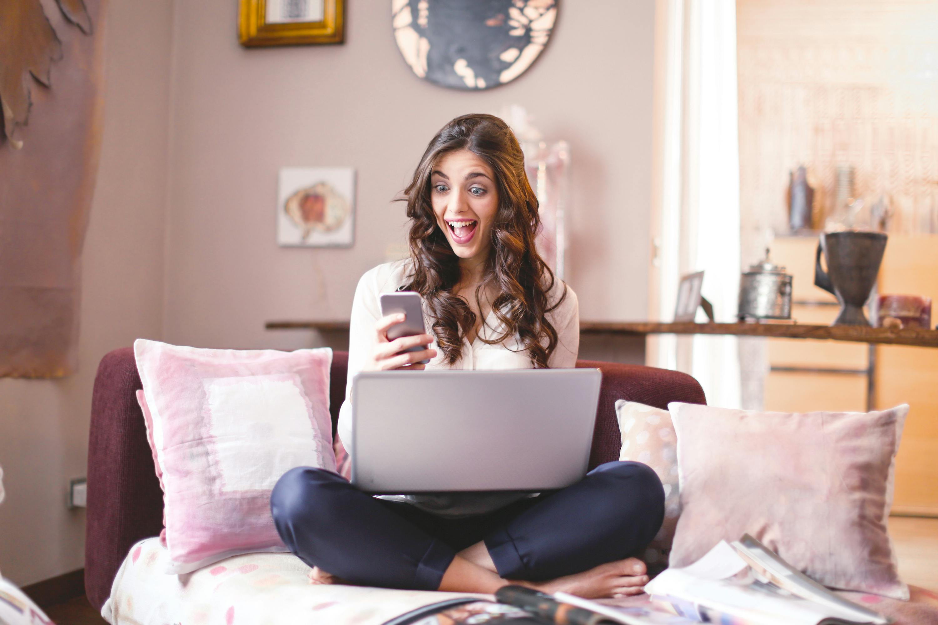 A woman reacting in shock while looking at her phone | Source: Pexels