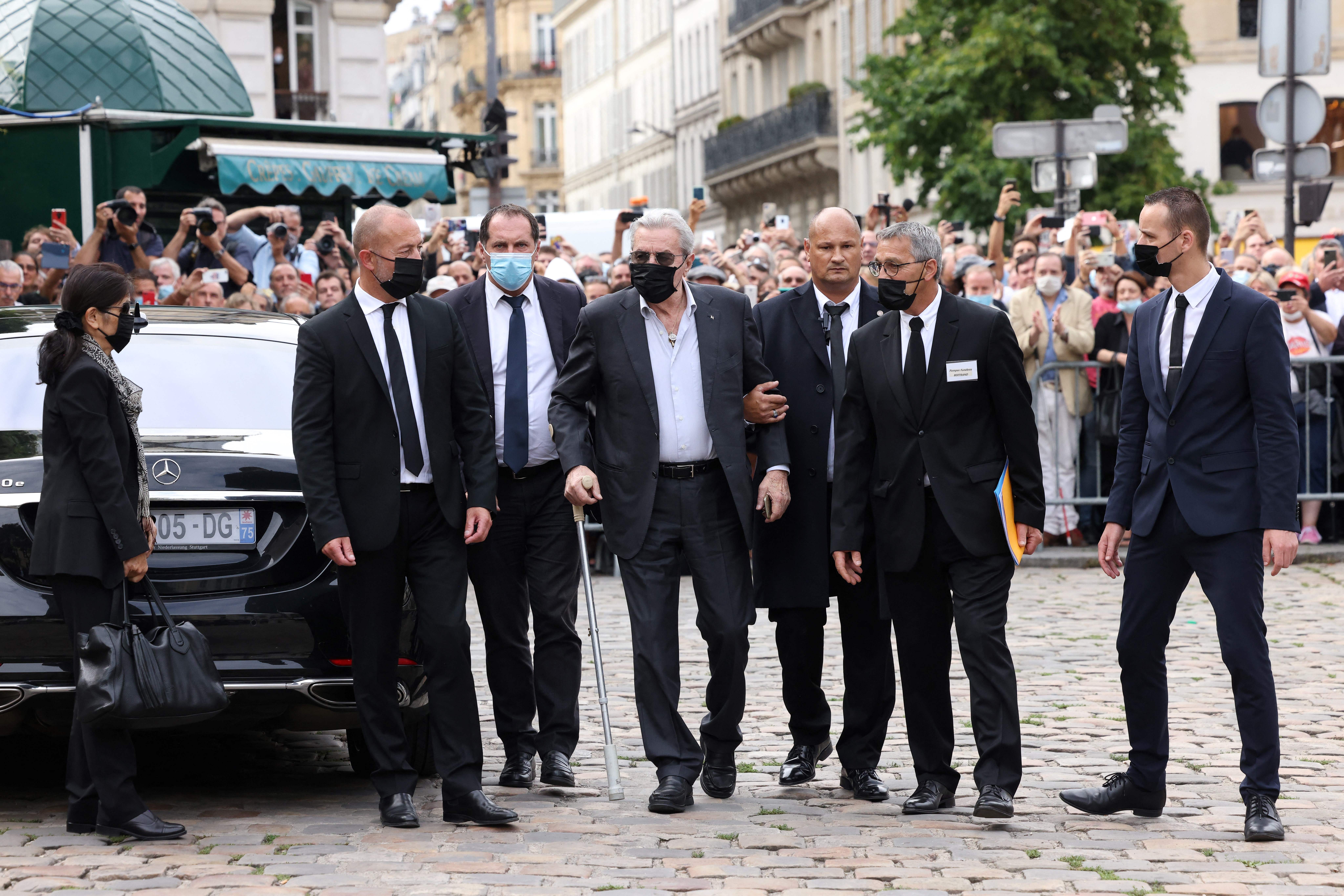 Alain Delon (C) arrives with his partner and assistant Hiromi Rollin (L) for the funeral ceremony for late French actor Jean-Paul Belmondo in Paris on September 10, 2021 | Source: Getty Images