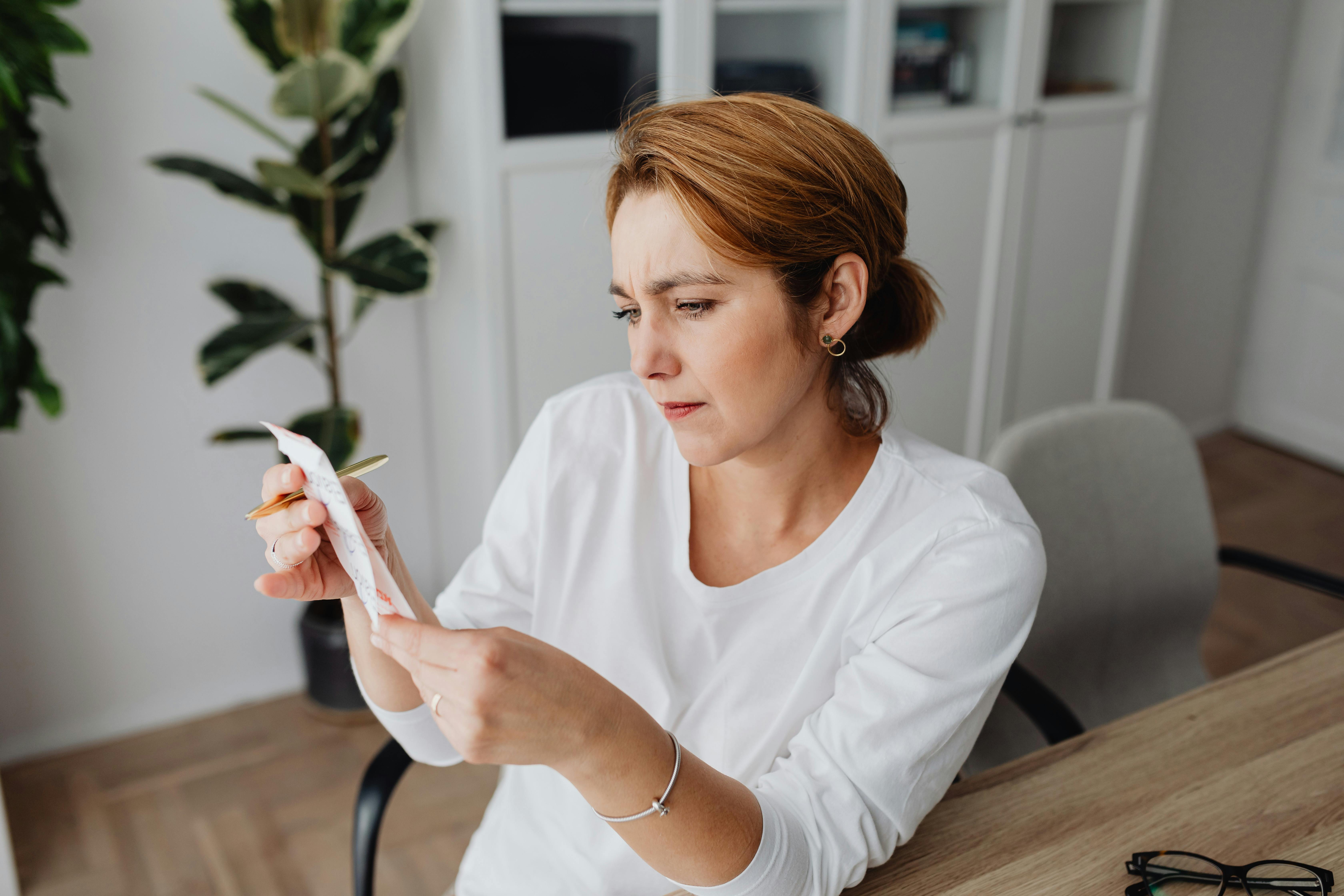 A confused woman looking at a receipt | Source: Pexels
