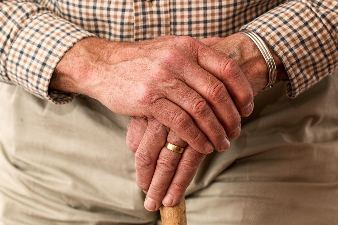 The hands of an elderly man holding a cane. | Photo: Pixabay.