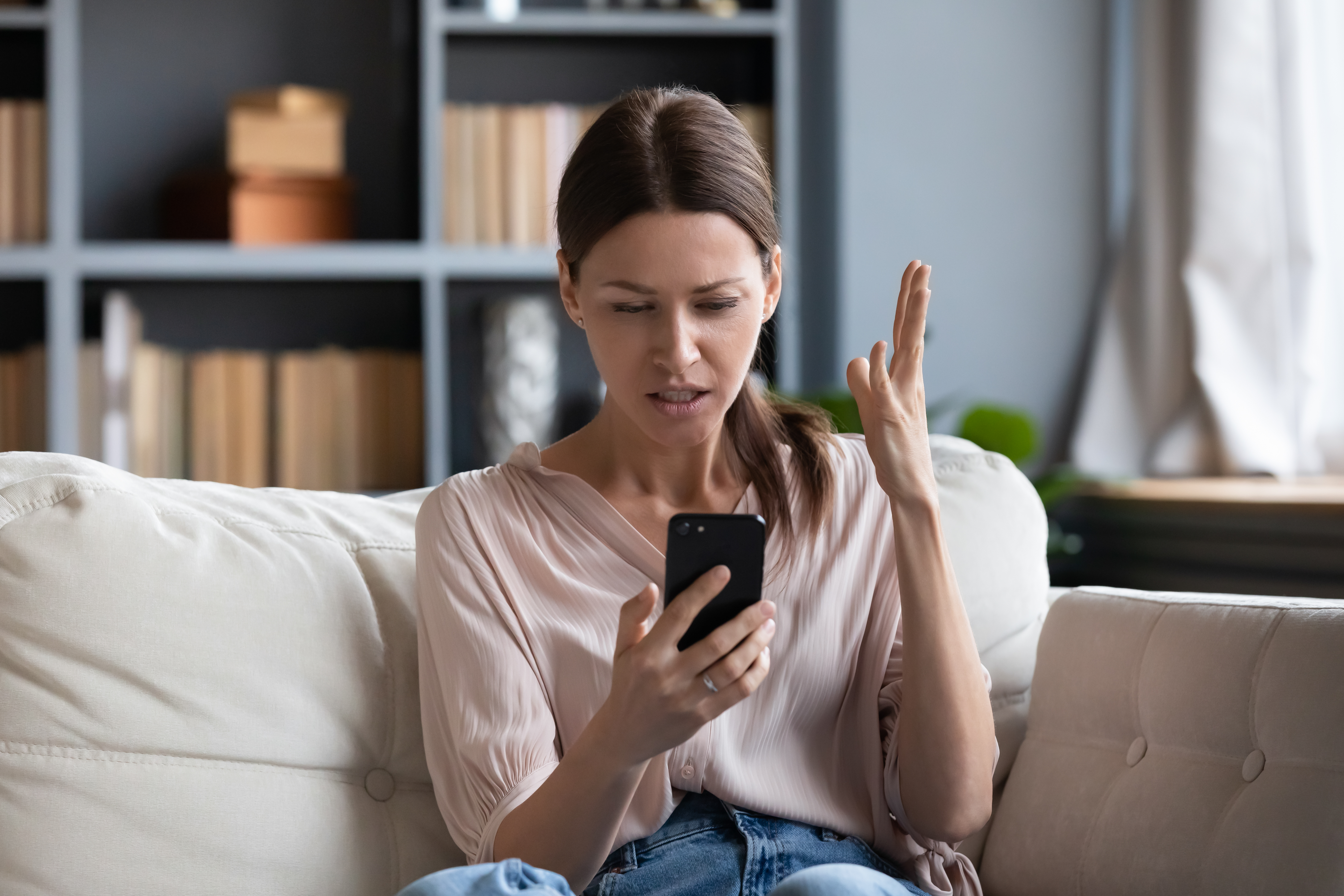 An annoyed woman looking at her phone | Source: Shutterstock