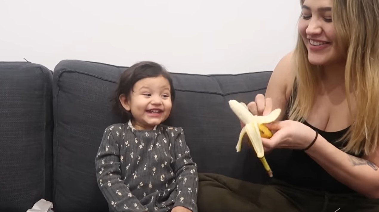 Petite fille est enthousiasmée par le cadeau de Noël banane | Photo: YouTube / LGNDFRVR