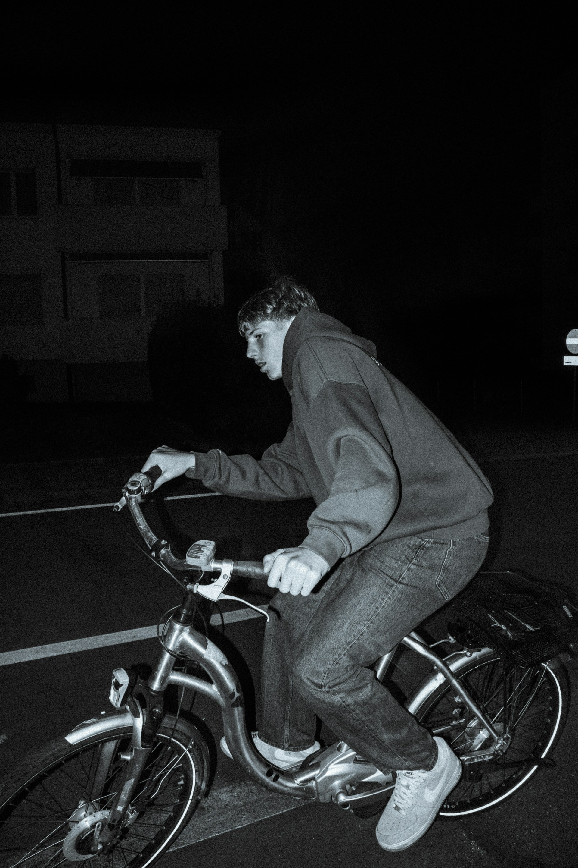 Grayscale shot of a young lad cycling on the road | Source: Unsplash