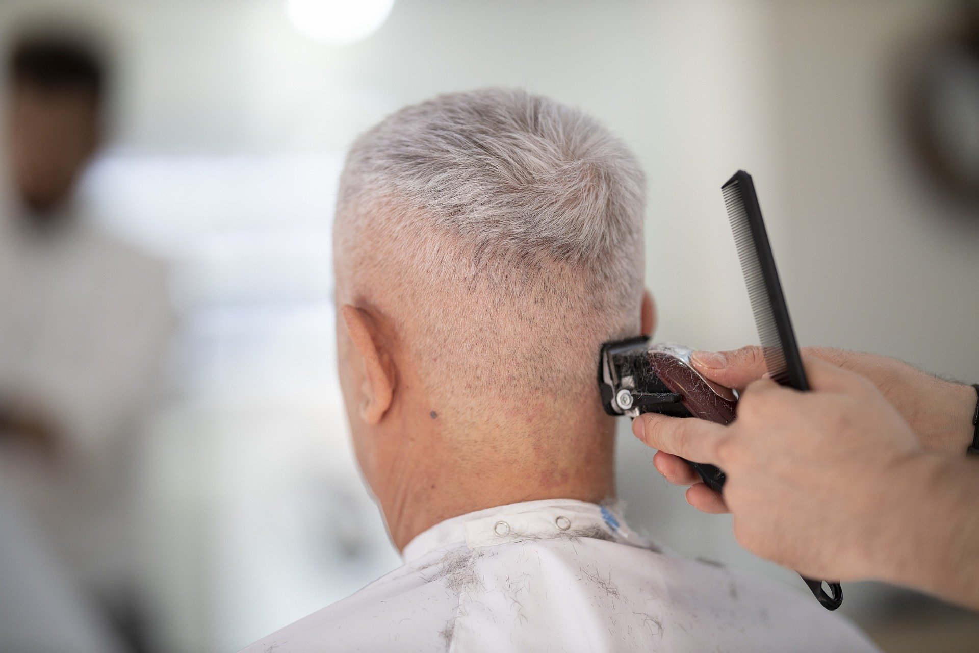 Un homme avec les cheveux blancs chez le coiffeur | Photo : Pixabay.