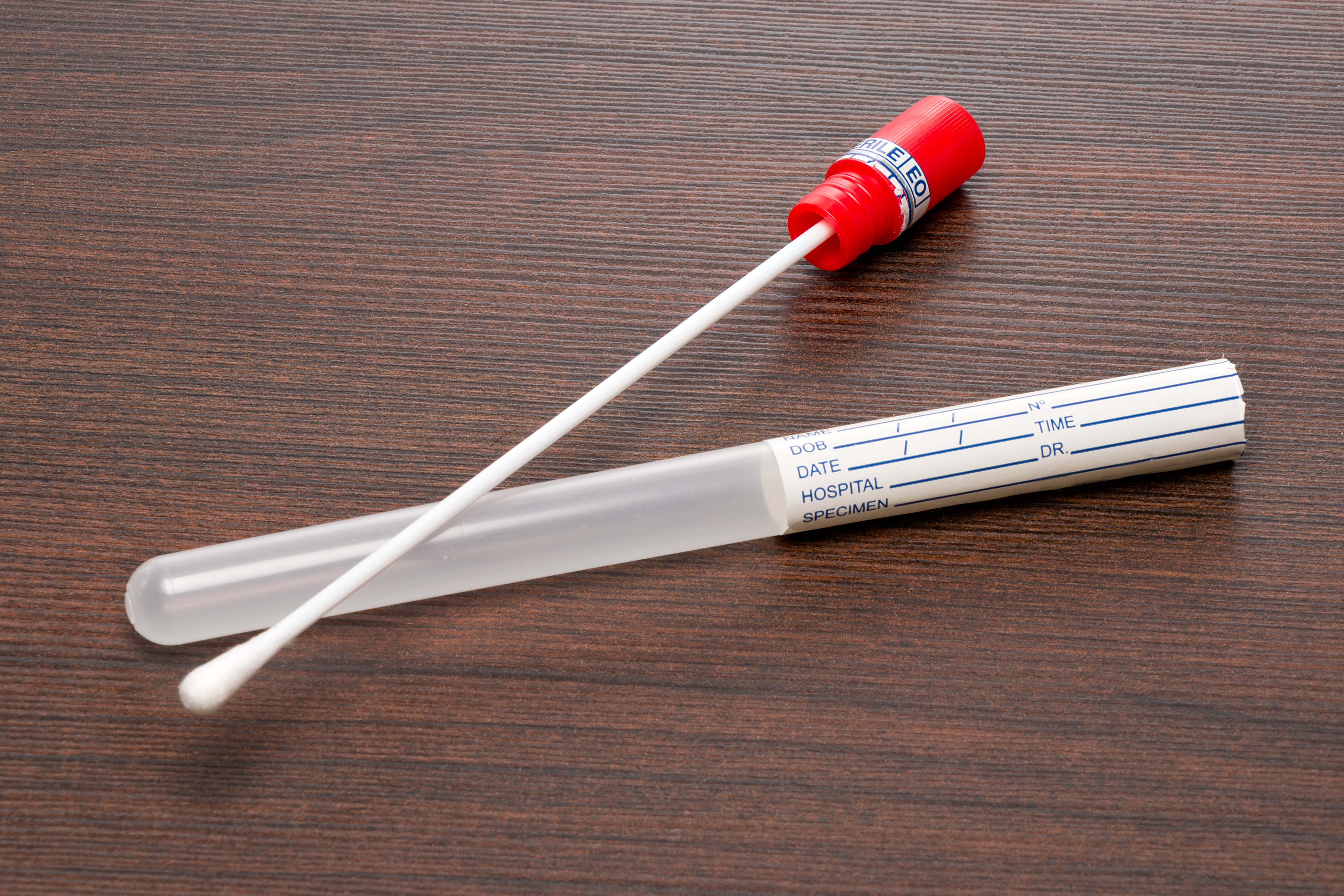 Ein DNA-Reagenzglas und ein Wattestäbchen. | Quelle: Shutterstock