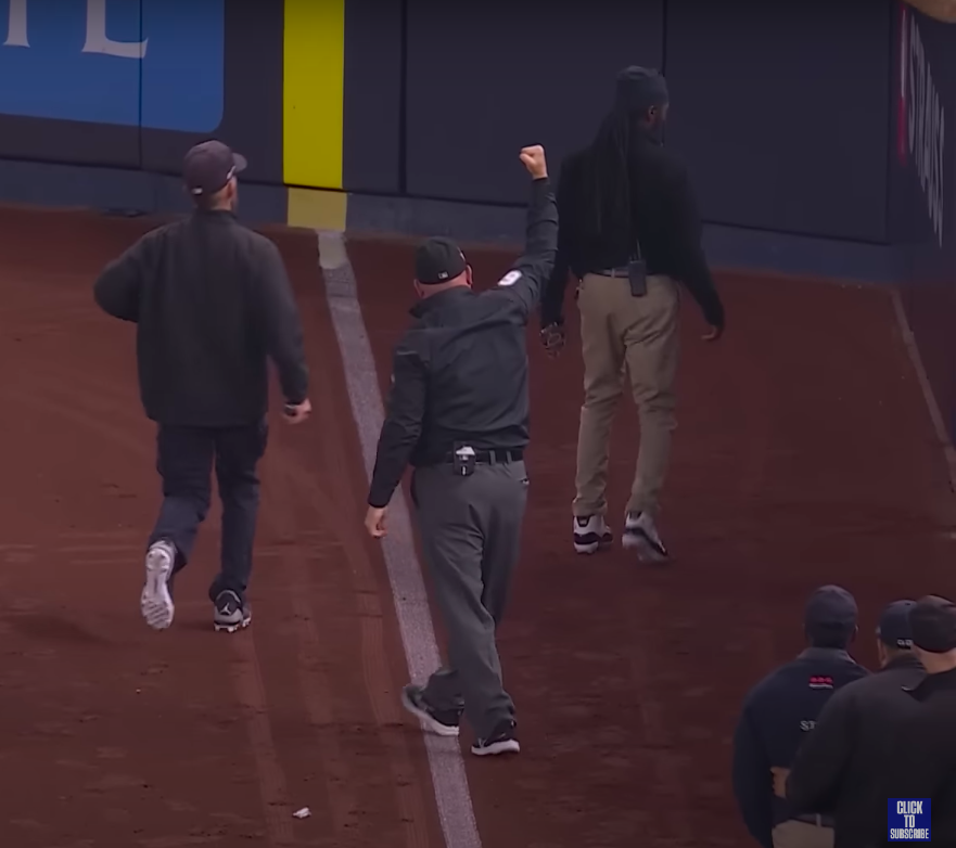 Right-field umpire Mark Carlson making the ruling and security personnel dealing with the matter. | Source: YouTube/FOX Sports