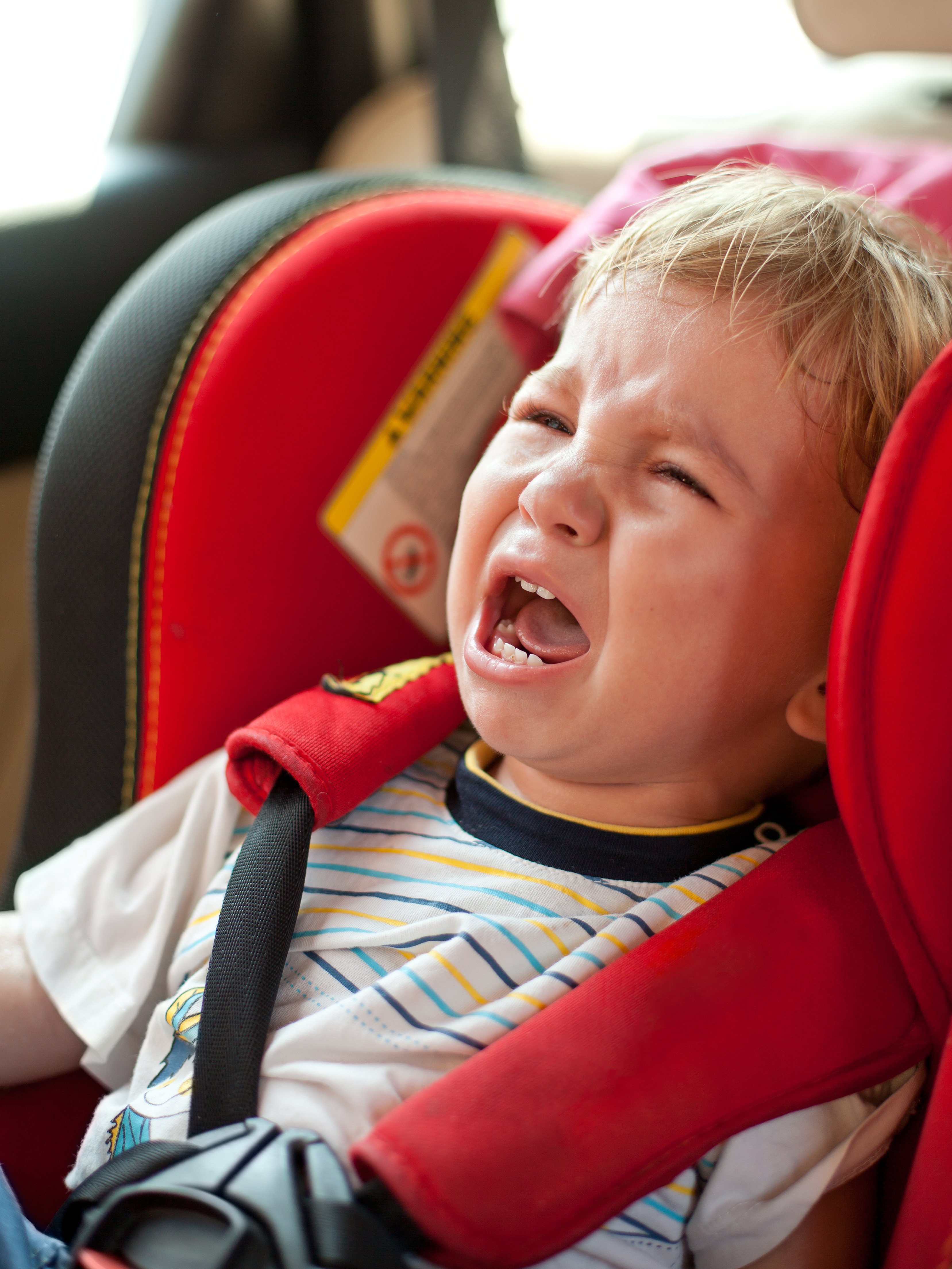 Little boy crying inside a car | Photo: Shutterstock