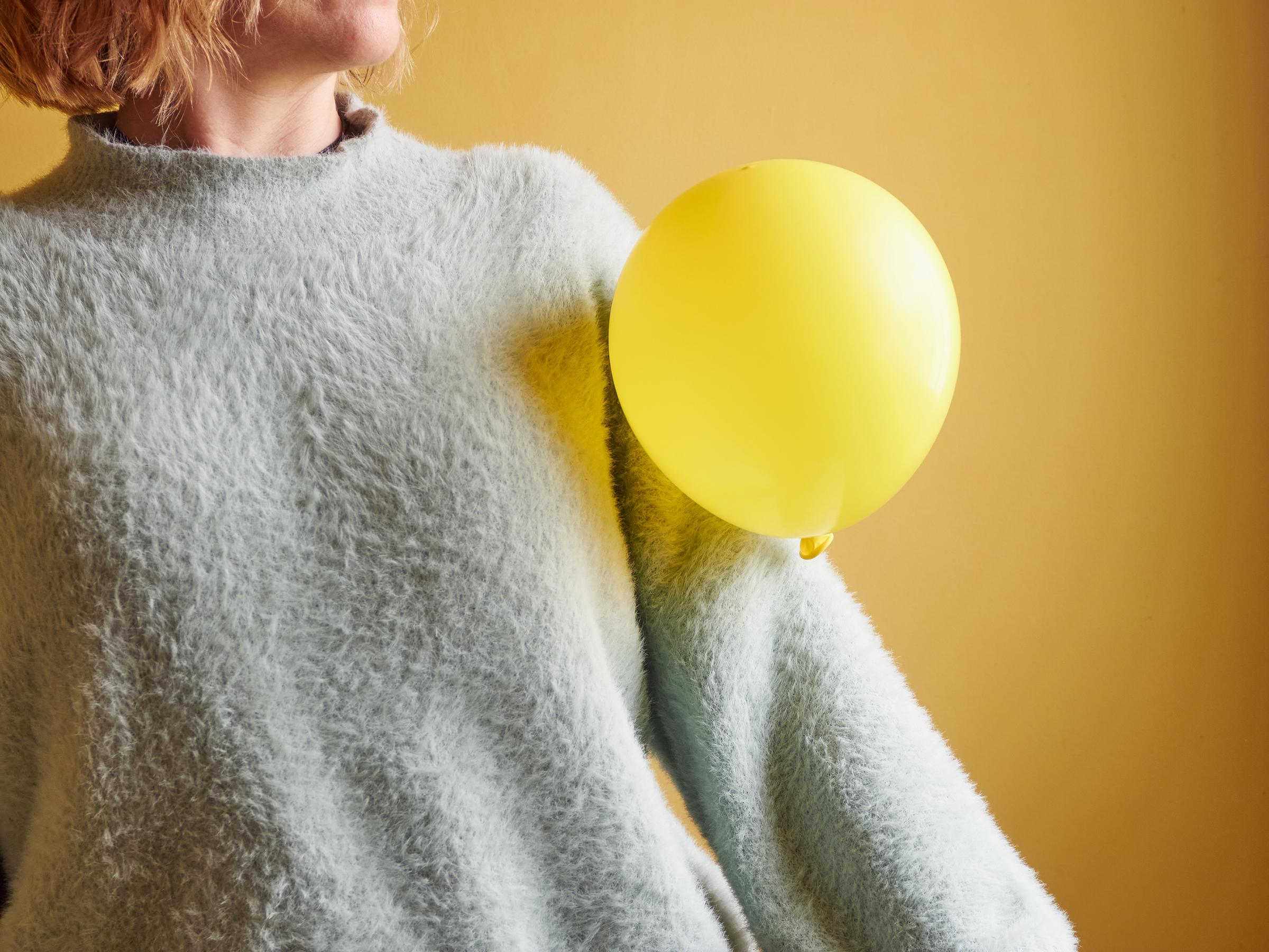 A yellow balloon attached to a woman's sweater | Source: Getty Images