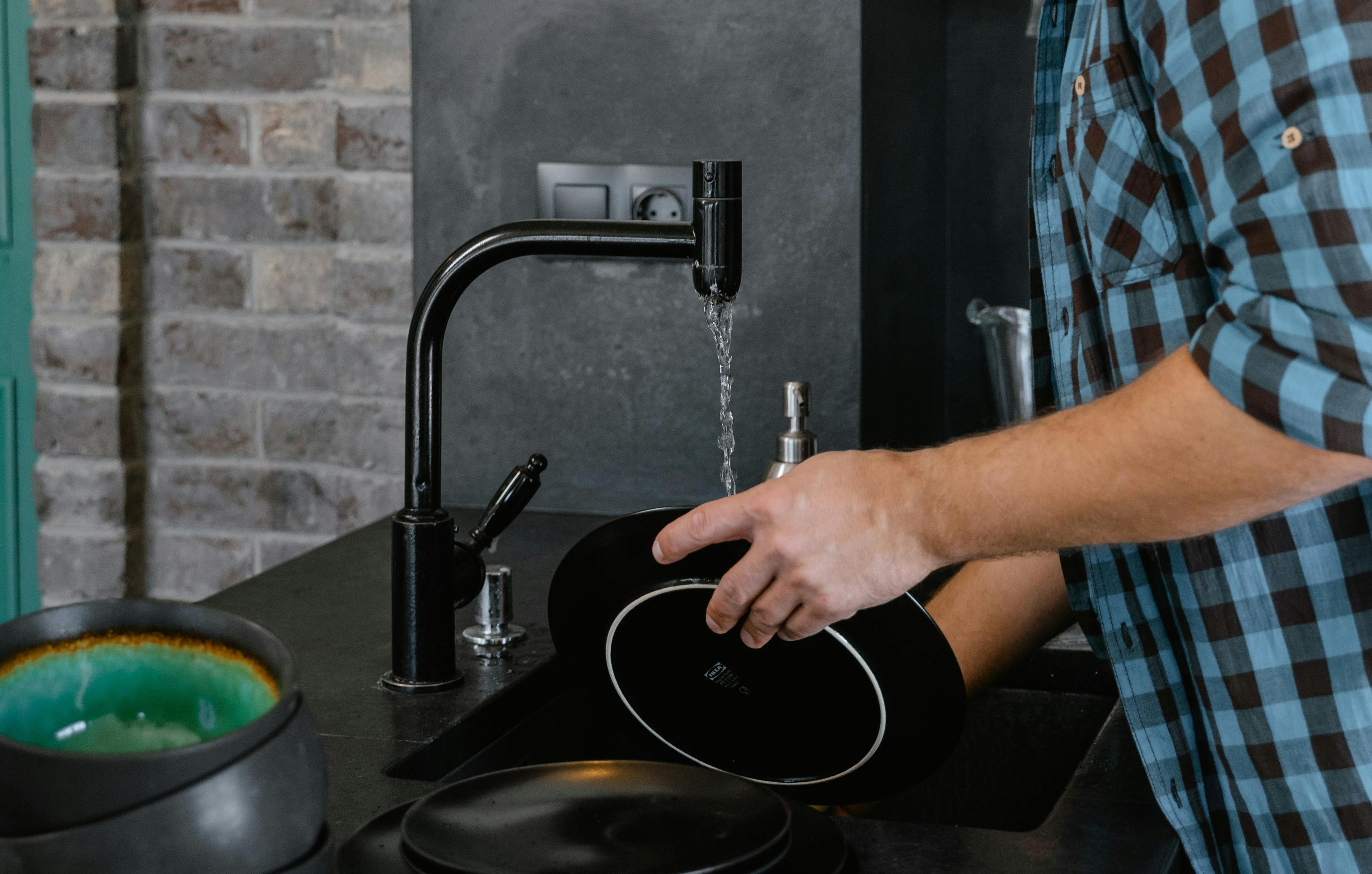 Close-up of a man washing dishes | Source: Pexels