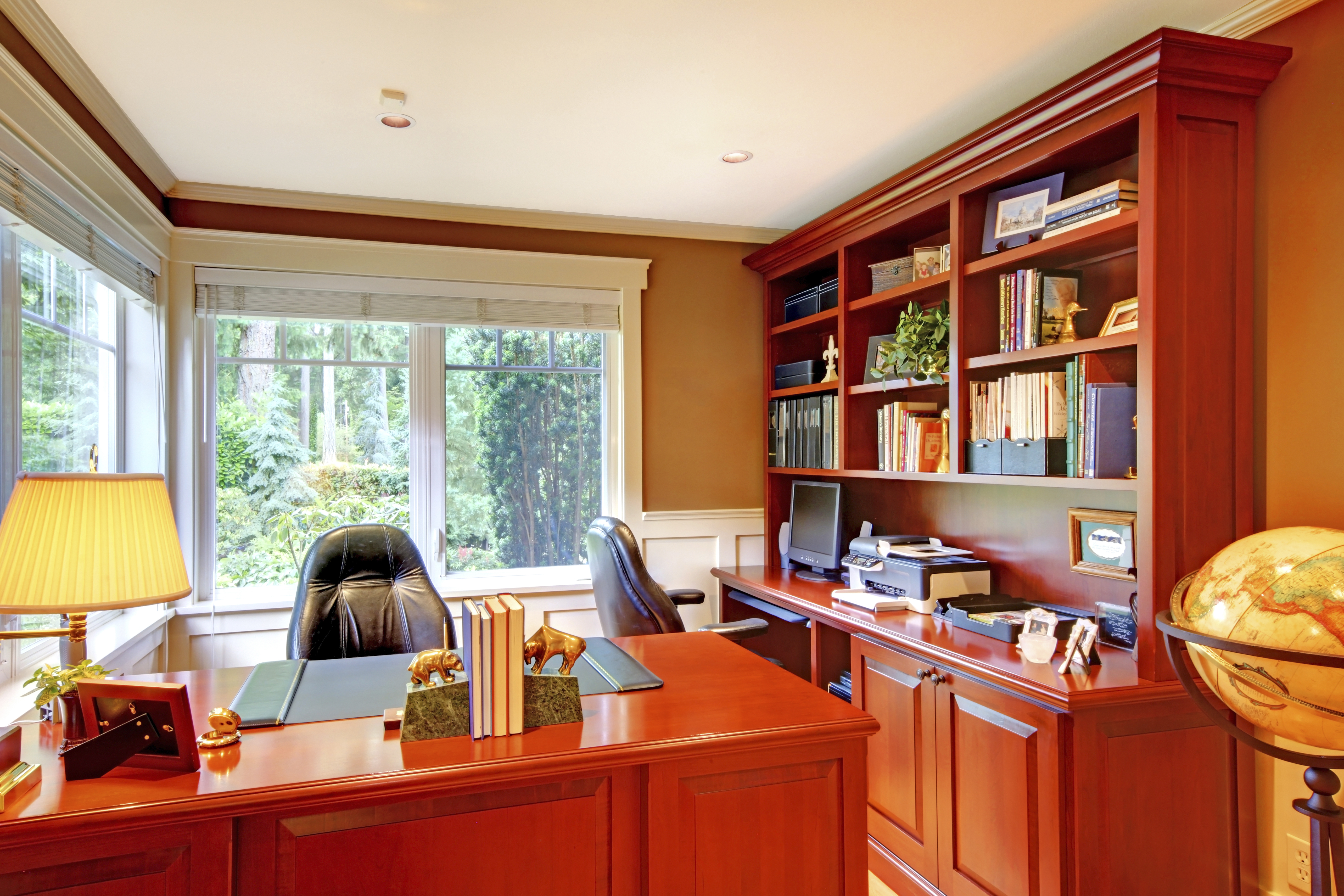 Office luxury interior with grey walls and wood. Furnished with wooden desk and leather chairs. | Source: Shutterstock