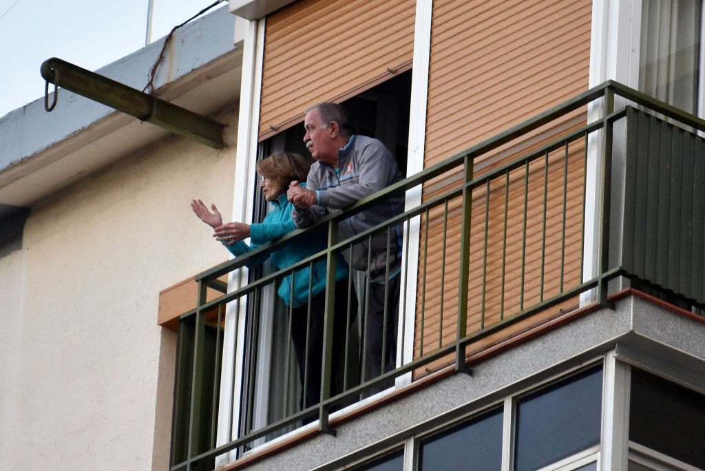Una pareja aplaude desde la terraza de su casa para mostrar gratitud a los combatientes del covid-19. | Foto de Ramón Costa a través de Getty Images