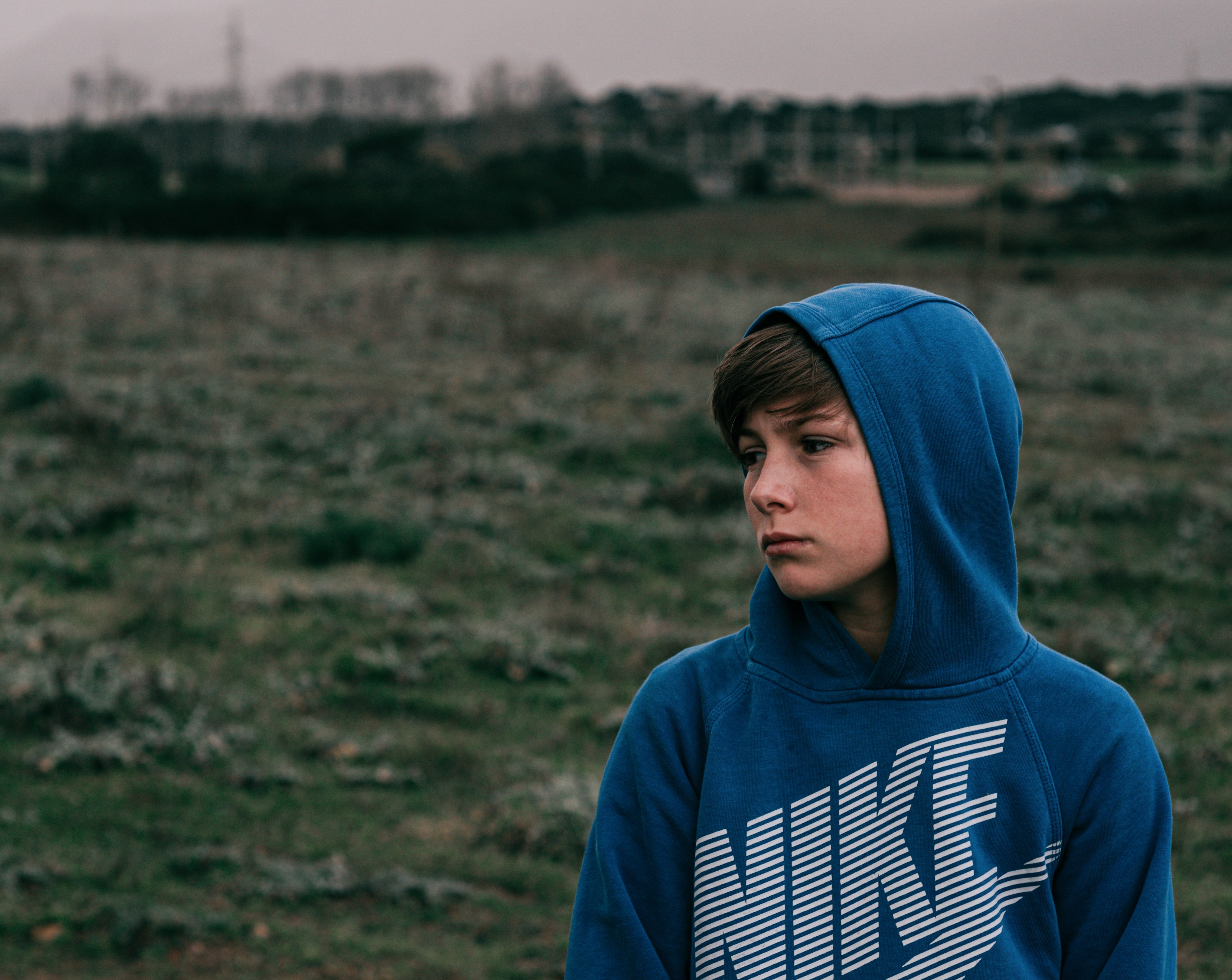 Sad boy wearing a bllue hoodie | Source: Unsplash / nicontents 