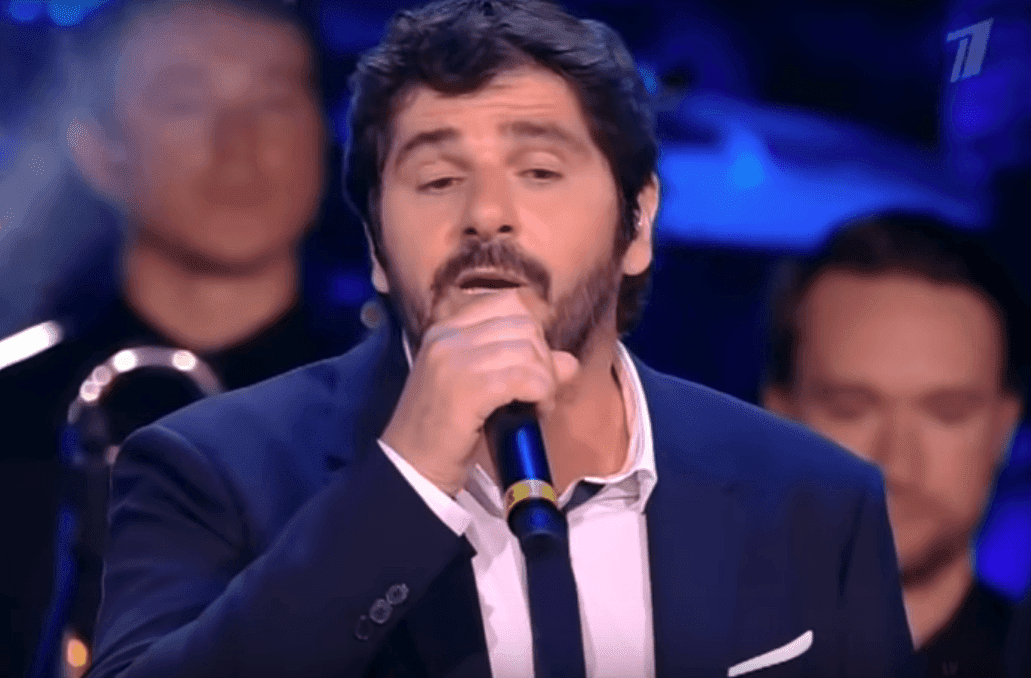 Patrick performant Une vie d'amour sur scene. | YouTube/SvetRimm