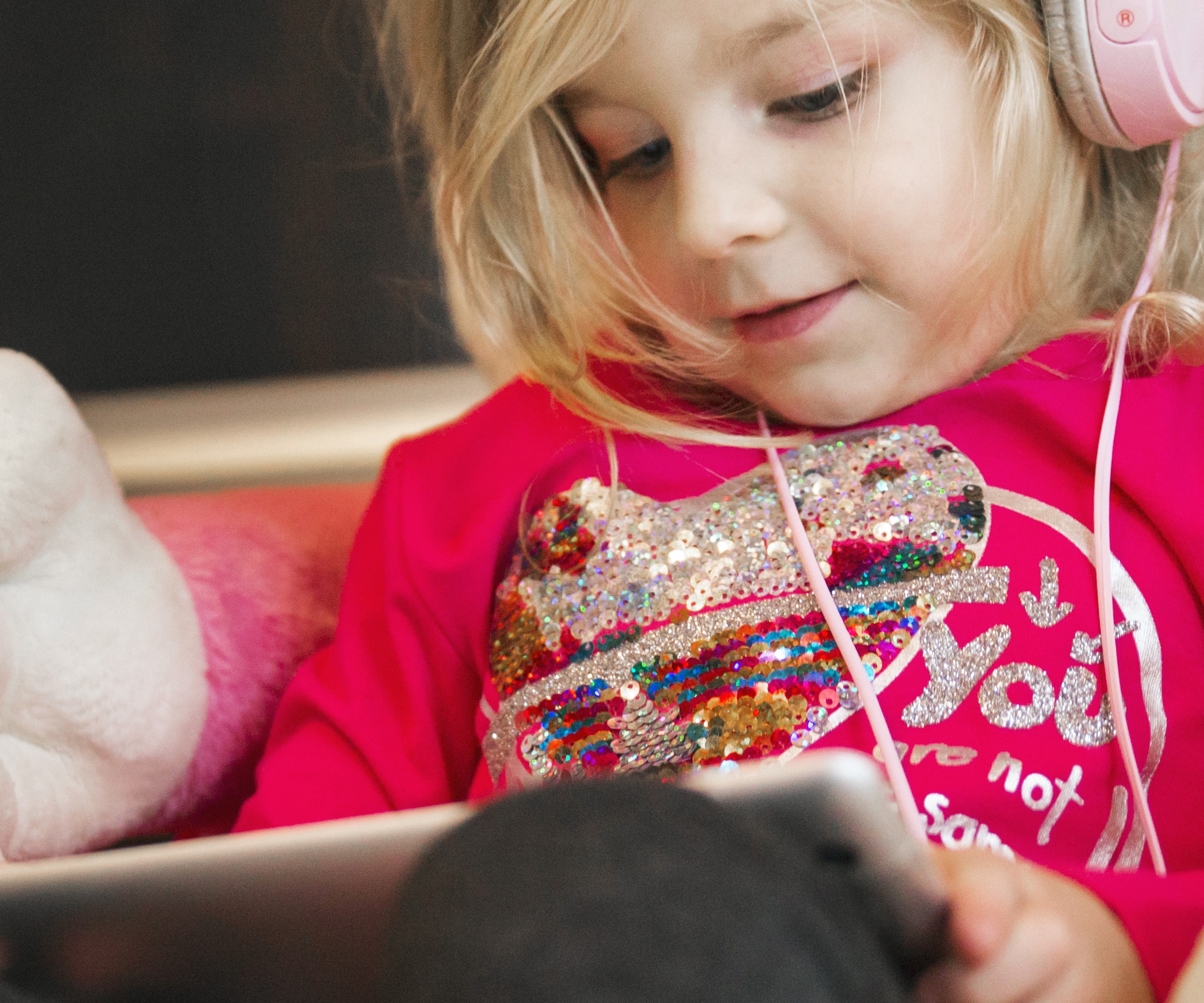 A cheerful little girl holding a tablet | Source: Freepik