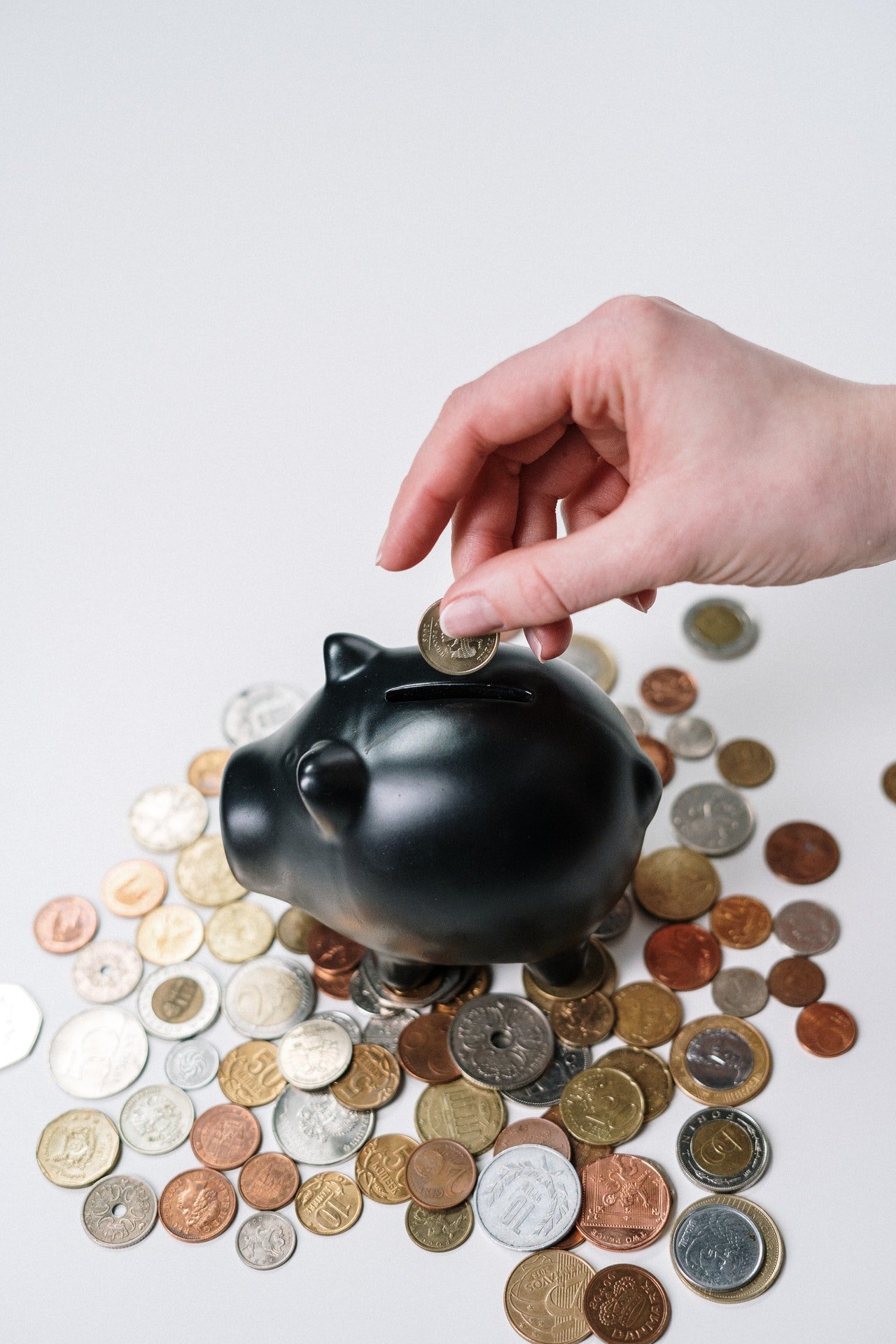 Person putting coin inside piggy bank | Source: Pexels