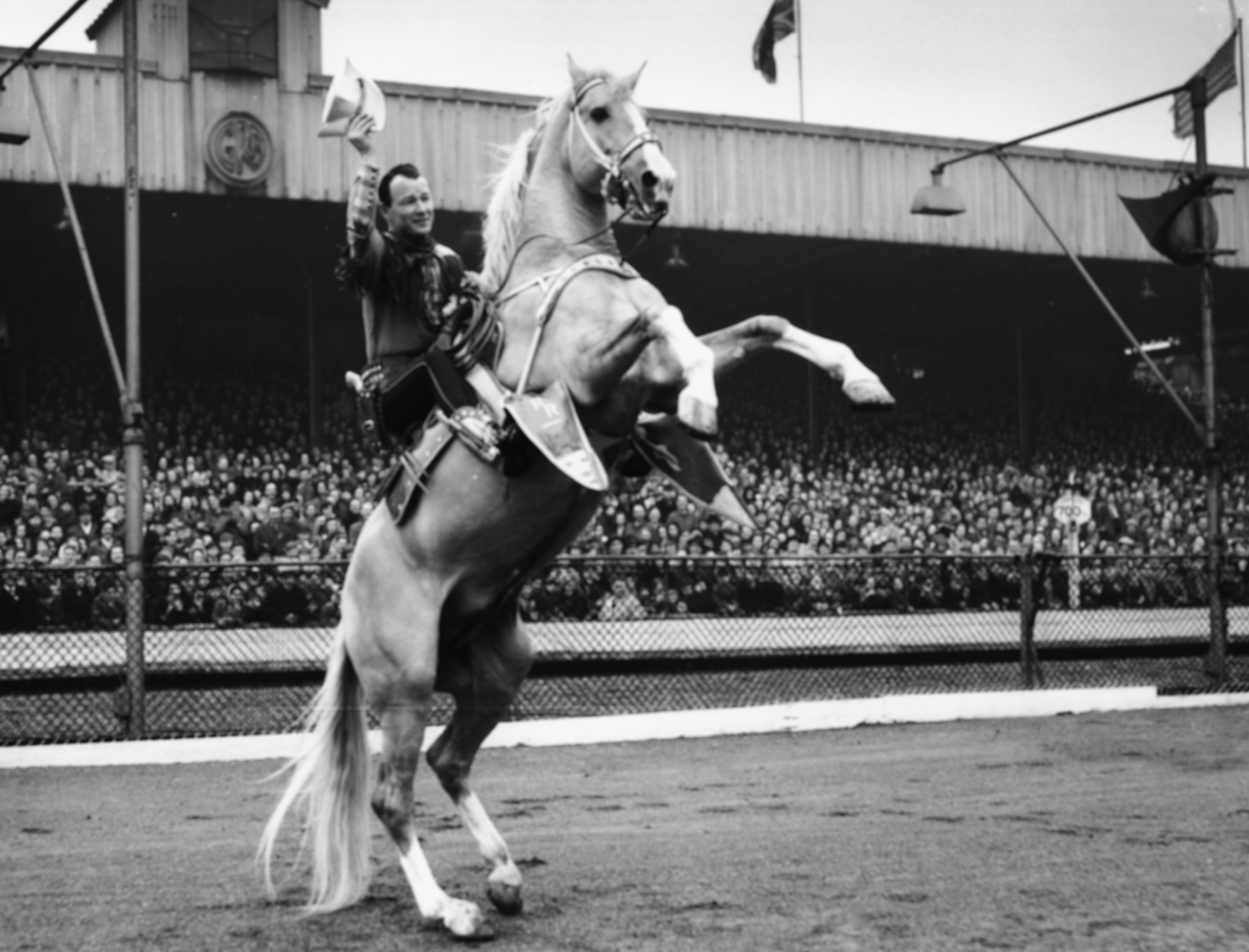 Actor Roy Rogers, the 'King of Cowboys', riding his horse Trigger in front of a group of school children at Harringay Stadium, London, March 20, 1954. | Source: Getty Images.