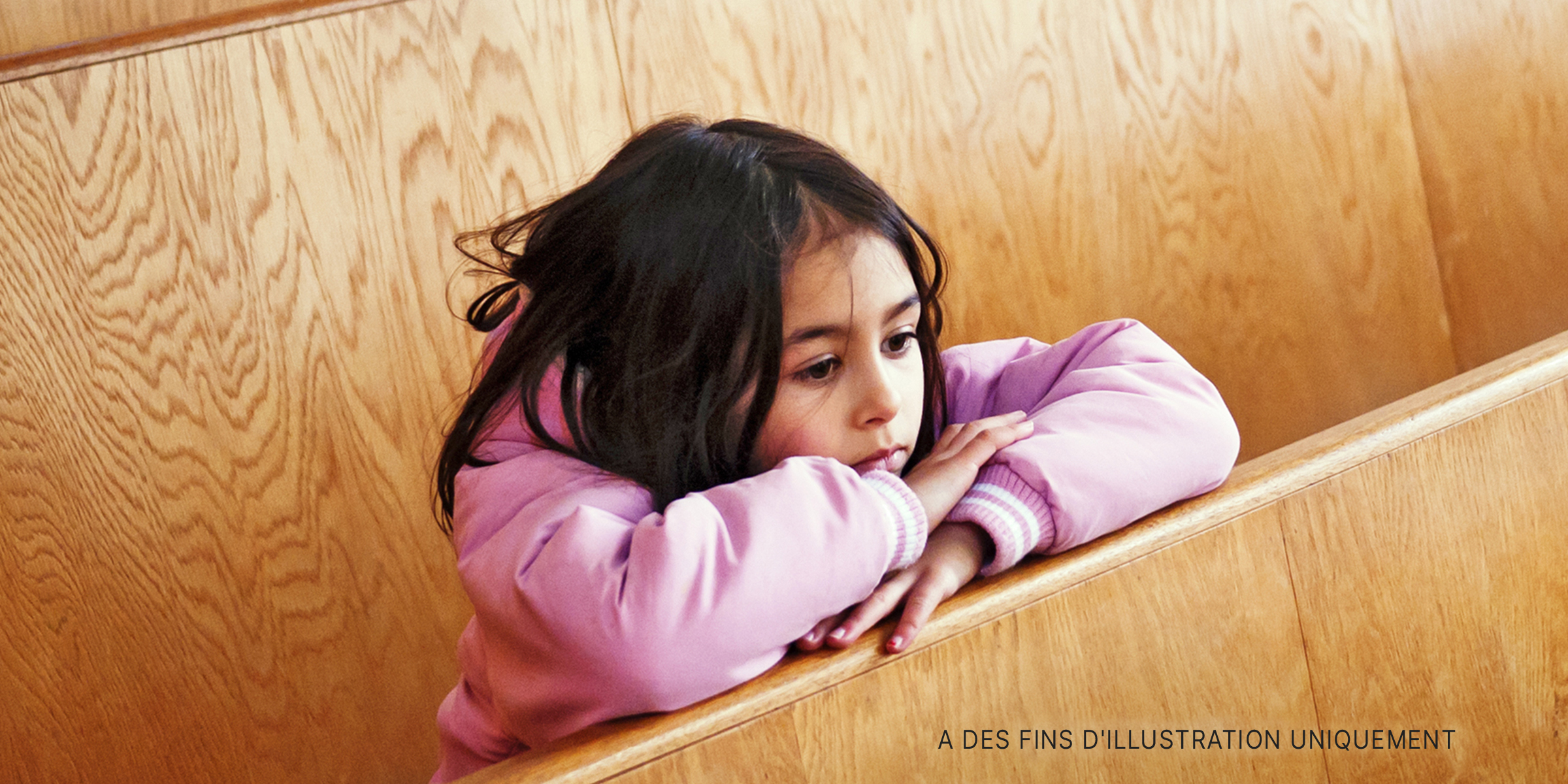 Une petite fille penchée entre les bancs. | Source : Getty Images