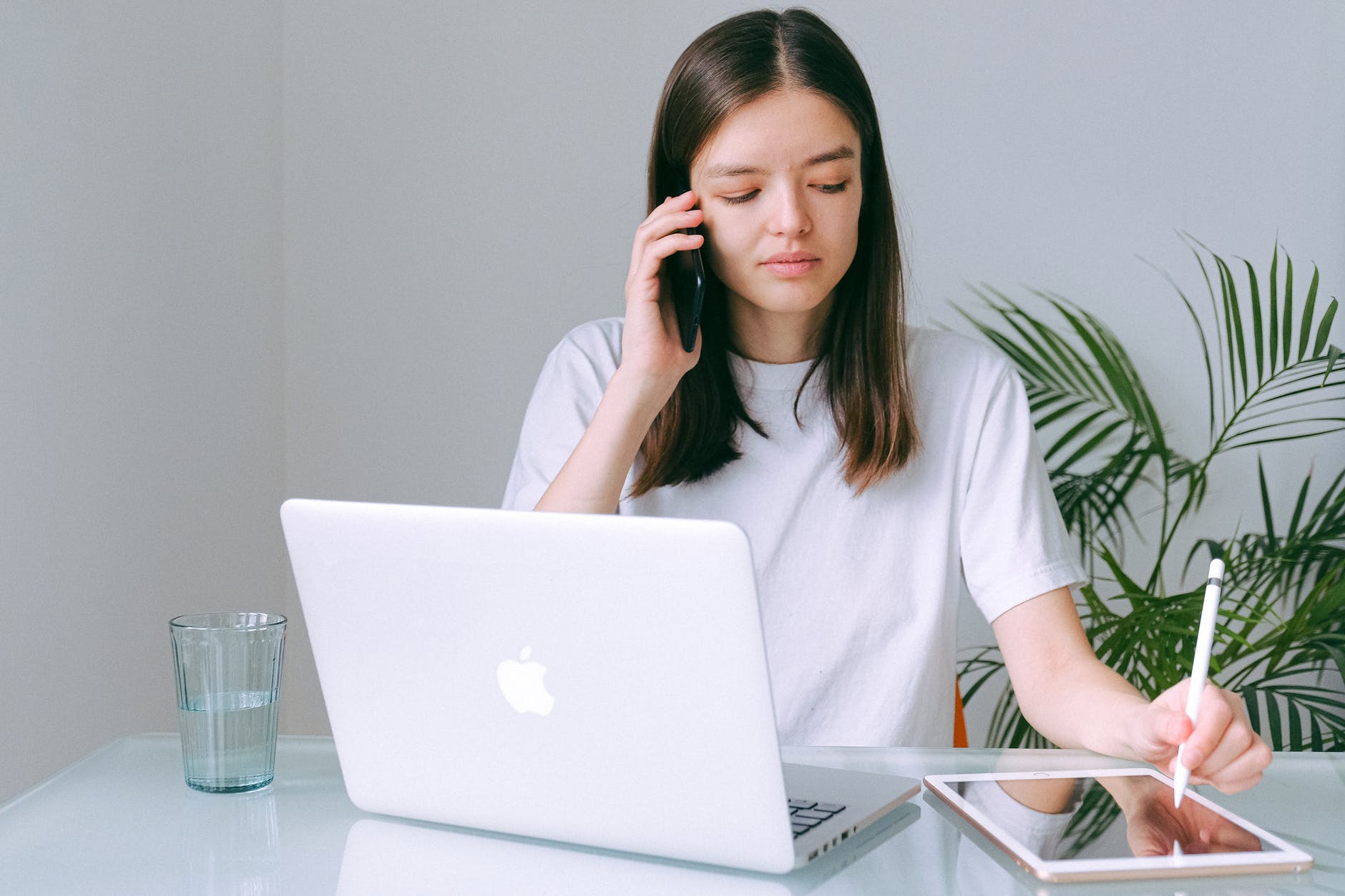 Eine junge Frau telefoniert mit einem Laptop vor sich. | Quelle: Pexels