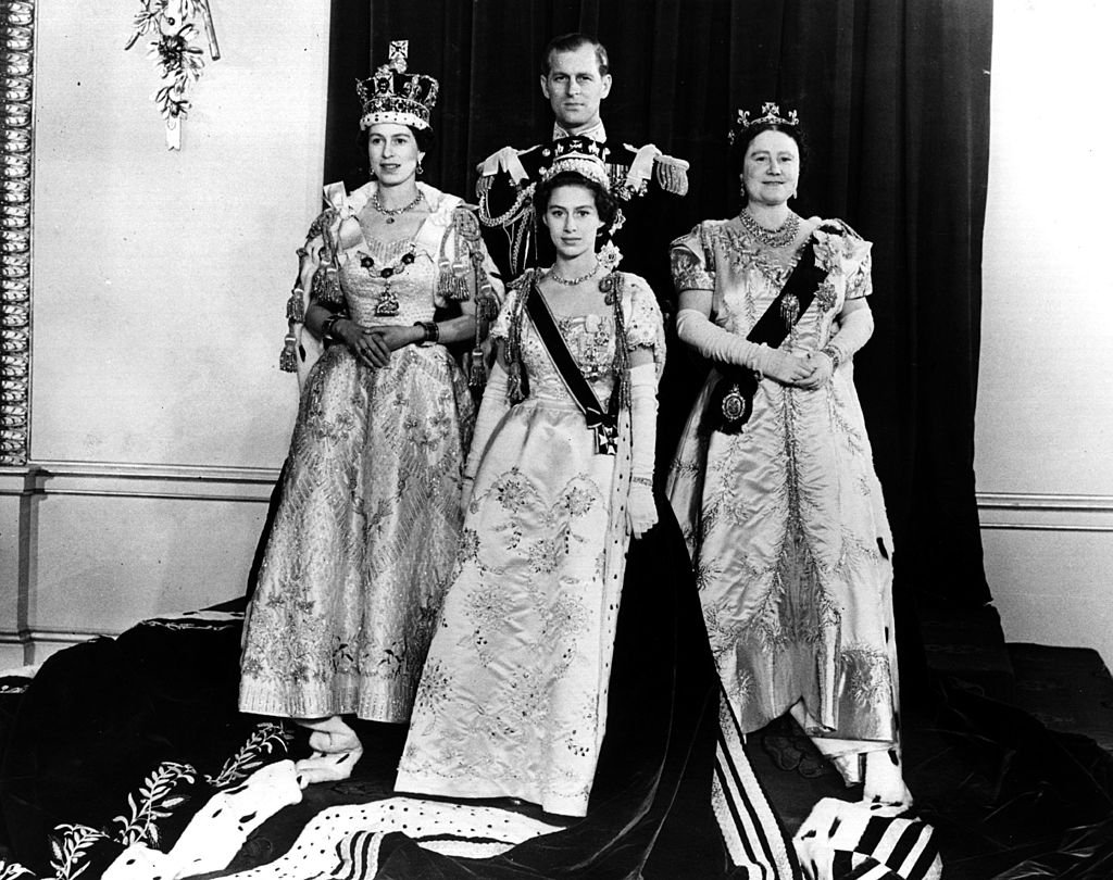 Queen Elizabeth II,  The Duke of Edinburgh, Queen Elizabeth the Queen Mother and Princess Margaret Rose pose in the throne room of Buckingham Palace after the Coronation ceremony. | Source: Getty Images