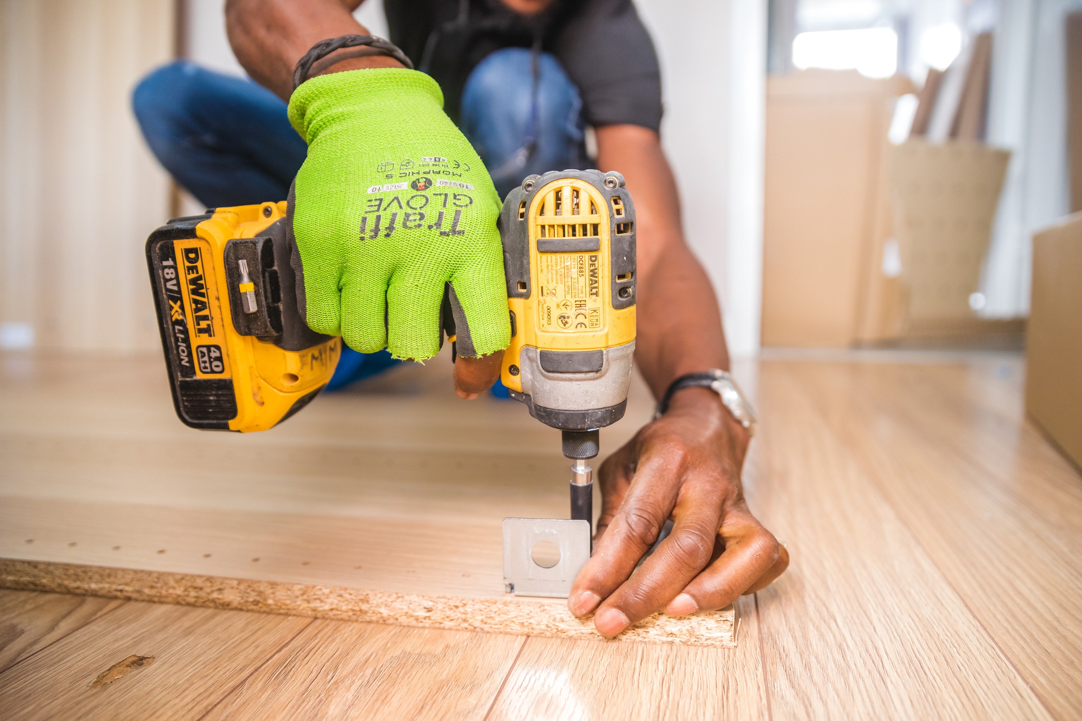 A handyman drilling into a piece of wood. | Photo: Pexels