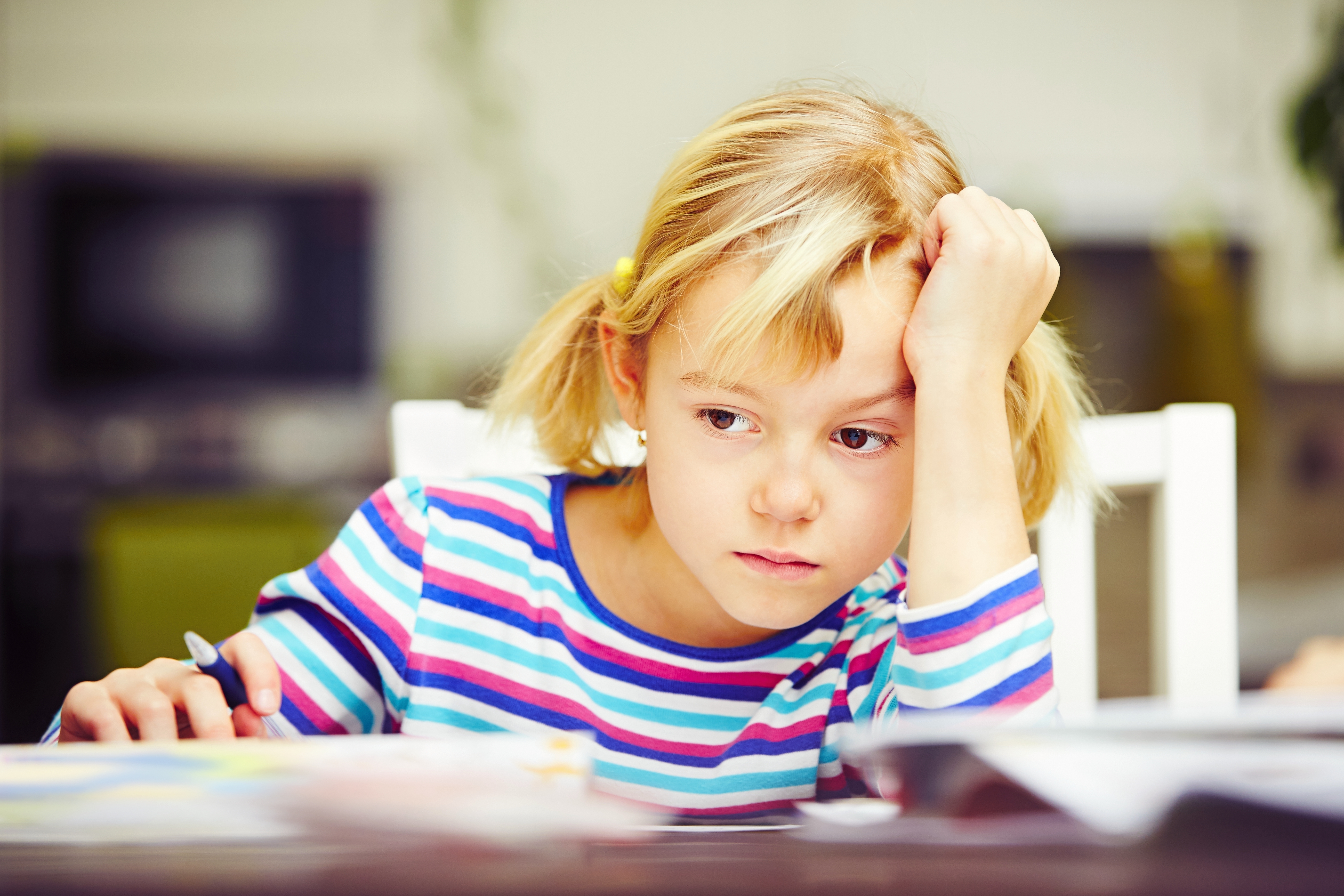 Little girl sulking in her desk | Source: Shutterstock
