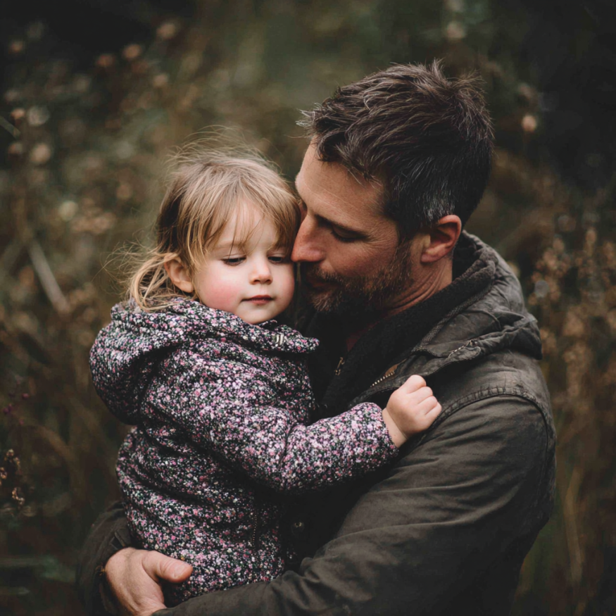 A dad holding his daughter | Source: Midjourney