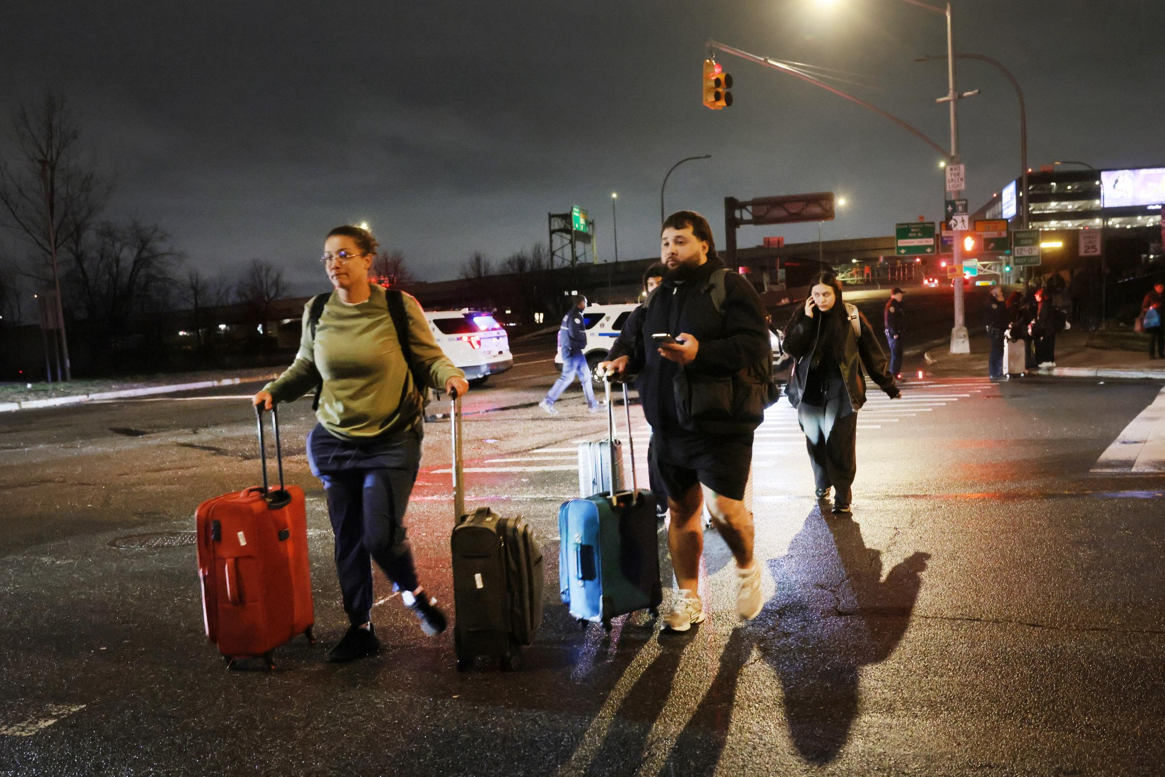 Travelers wheel their luggage away from LaGuardia Airport in New York on March 23, 2026 | Source: Getty Images