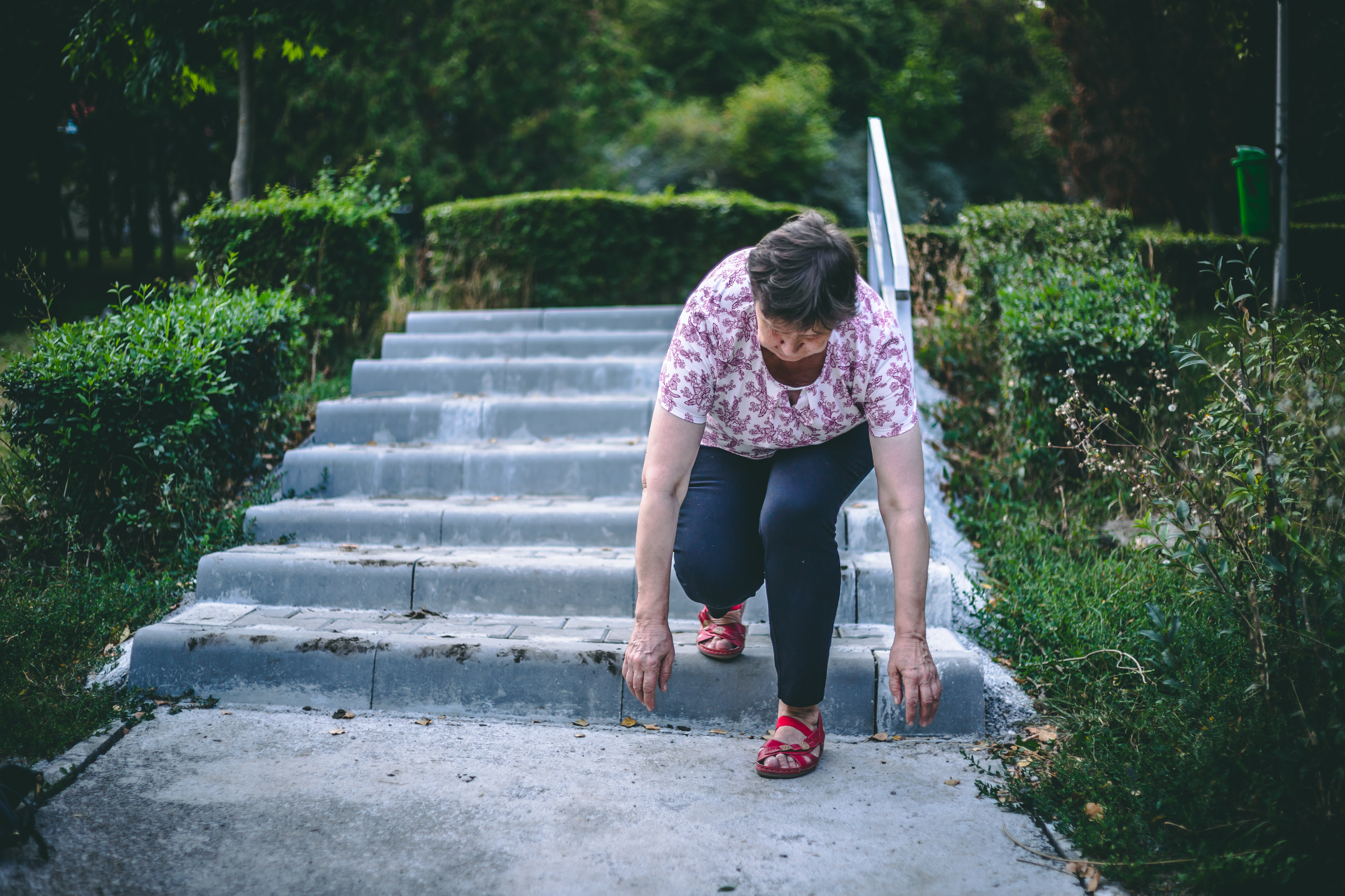 Weak senior woman slipping on stairs in the park. | Source: Shutterstock