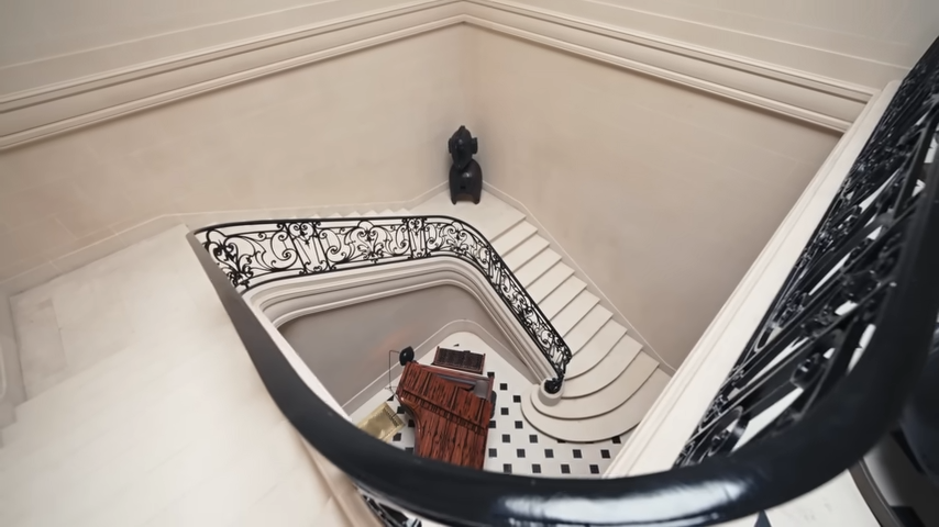 Looking down the spiral stairwell from the upper level reveals the stunning, continuous architectural curves of the home. | Source: YouTube/@Archdigest