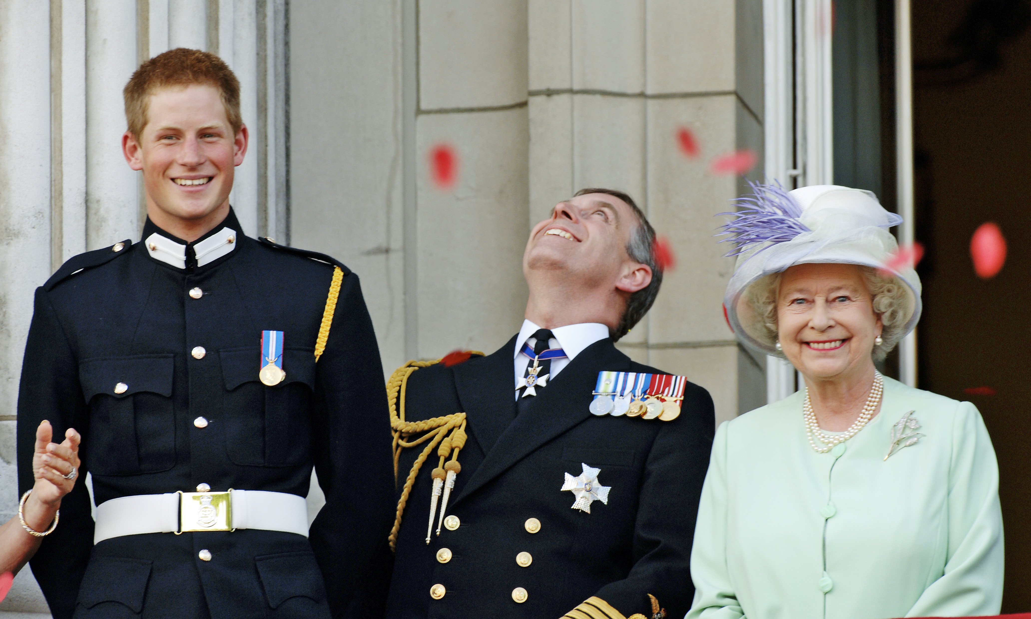 Prinz Harry in seiner Armeeuniform von Sandhurst, Prinz Andrew, der Herzog von York, und Königin Elizabeth beobachten am nationalen Gedenktag, dem 10. Juli 2005, vom Balkon des Buckingham Palasts den Vorbeiflug britischer und US-amerikanischer Flugzeuge aus dem Zweiten Weltkrieg, London. | Quelle: Getty Images