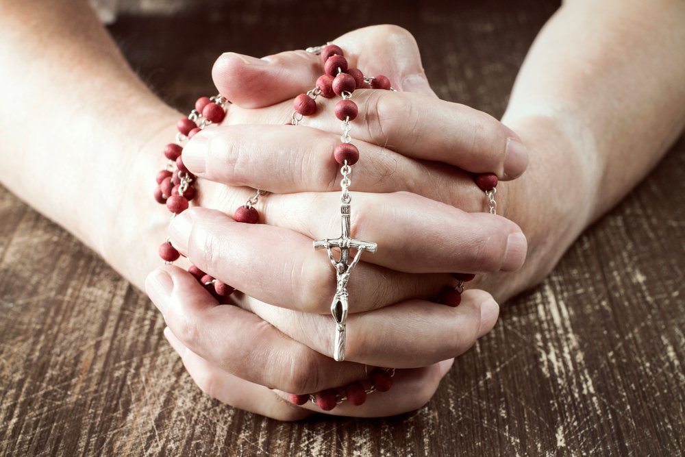 Persona rezando con un rosario en sus manos.| Fuente: Shutterstock Persona rezando con un rosario en sus manos.| Fuente: Shutterstock