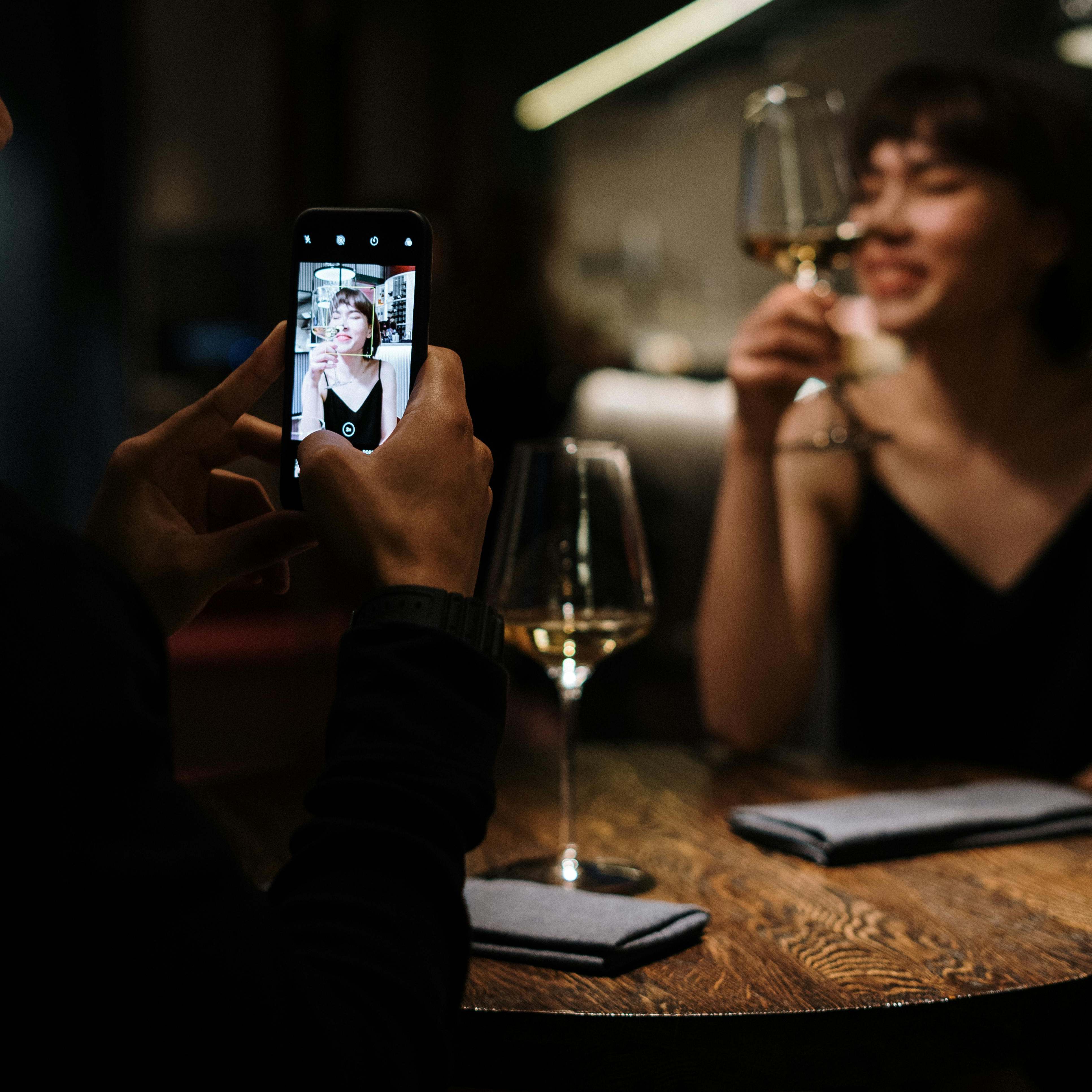 A man snapping a picture of a woman with his phone | Source: Pexels