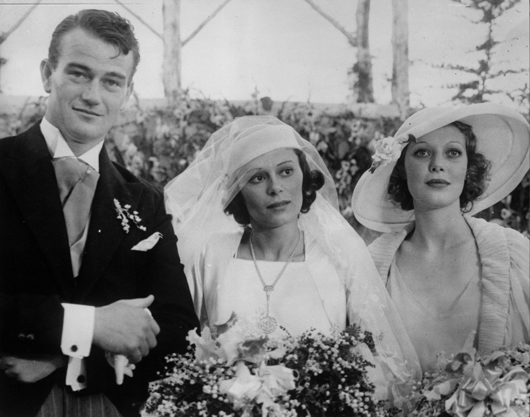 Film actor John John Wayne on his wedding day with his wife Josephine Saenz and Loretta Young. | Source: Getty Images