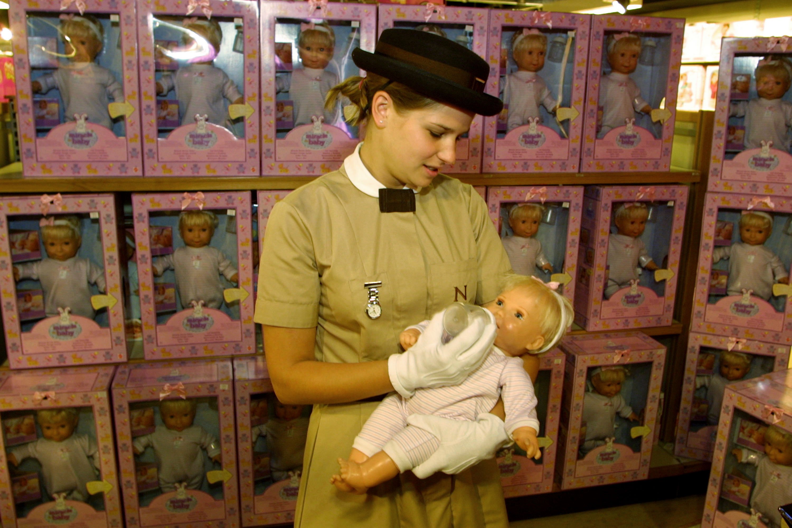 Anna-Louise Kemp, a nanny from the Norland Nanny College, tries out the new "Miracle Baby" doll August 1, 2001 at the doll''s launch in London. The doll contains a microchip that simulates the behavior of a 6-month-old baby. | Source: Getty Images.