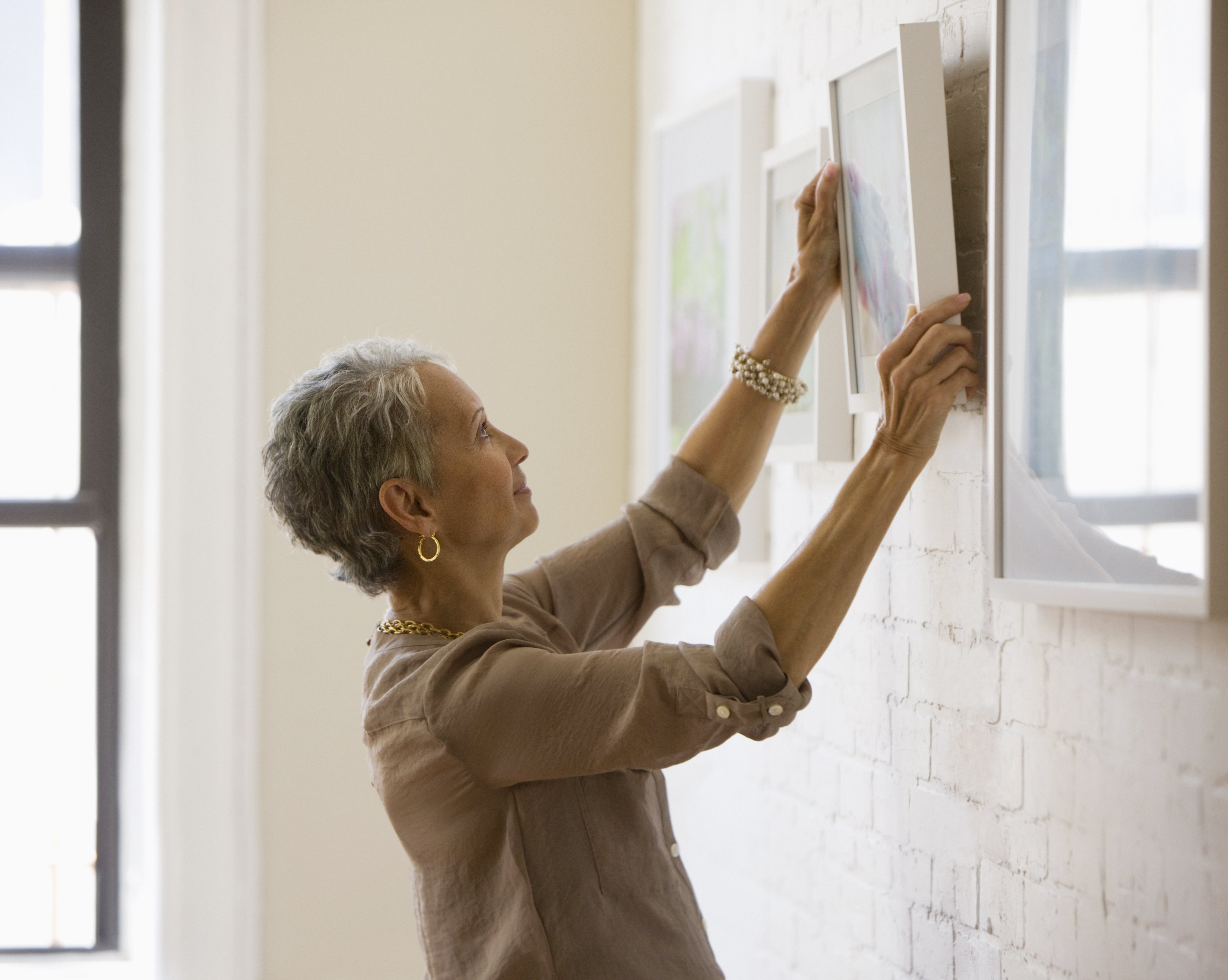  A woman pictured hanging pictures on the wall | Photo: Getty Images